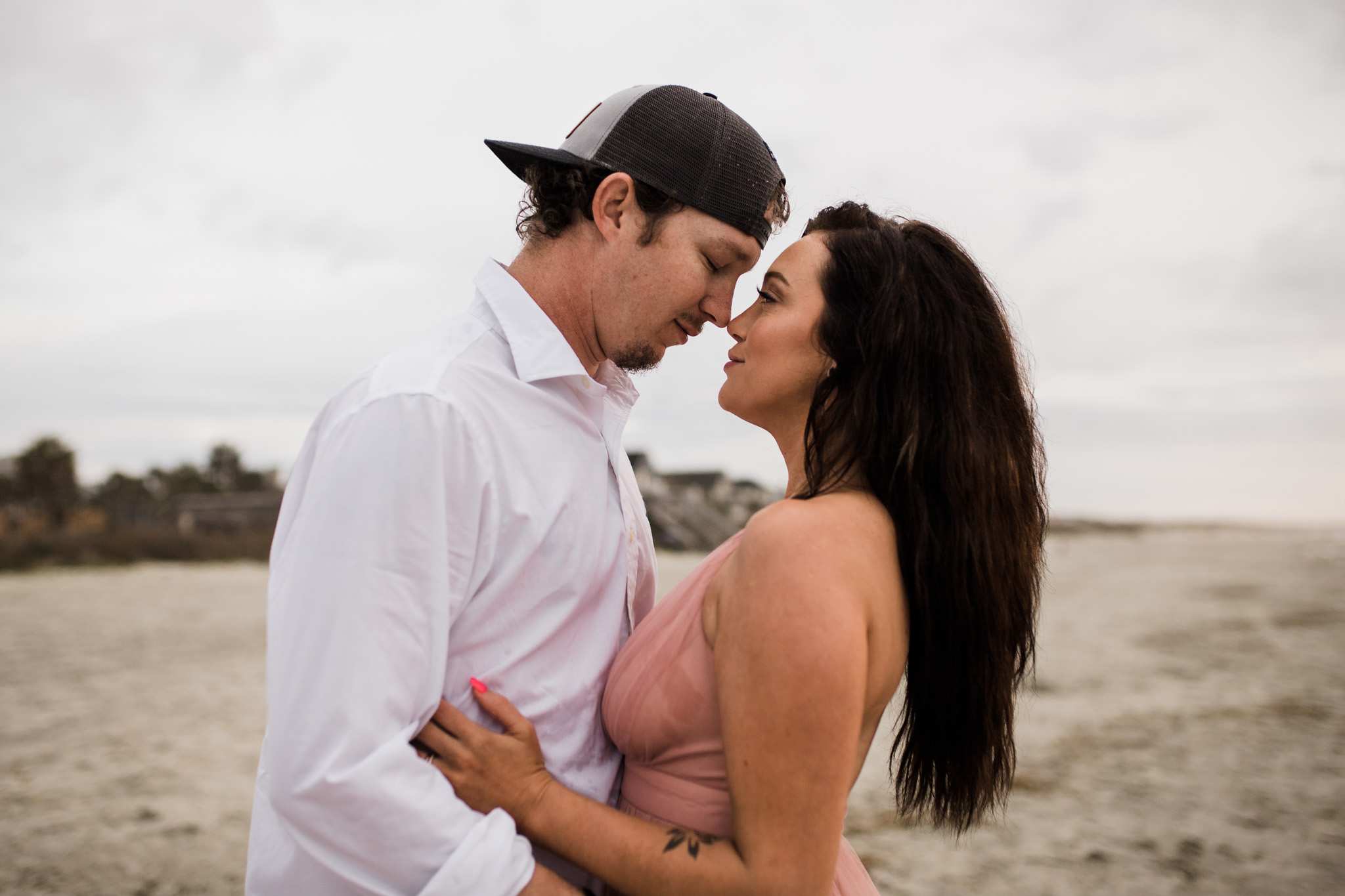 A couple embraces during their sunrise beach engagement session