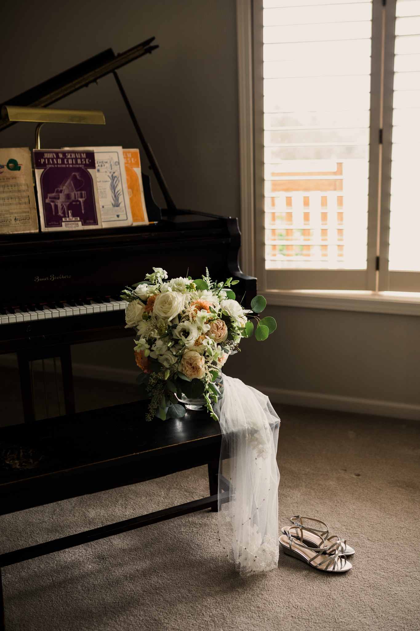 Details of a bouquet and veil by a piano, during an Indiana fall wedding.