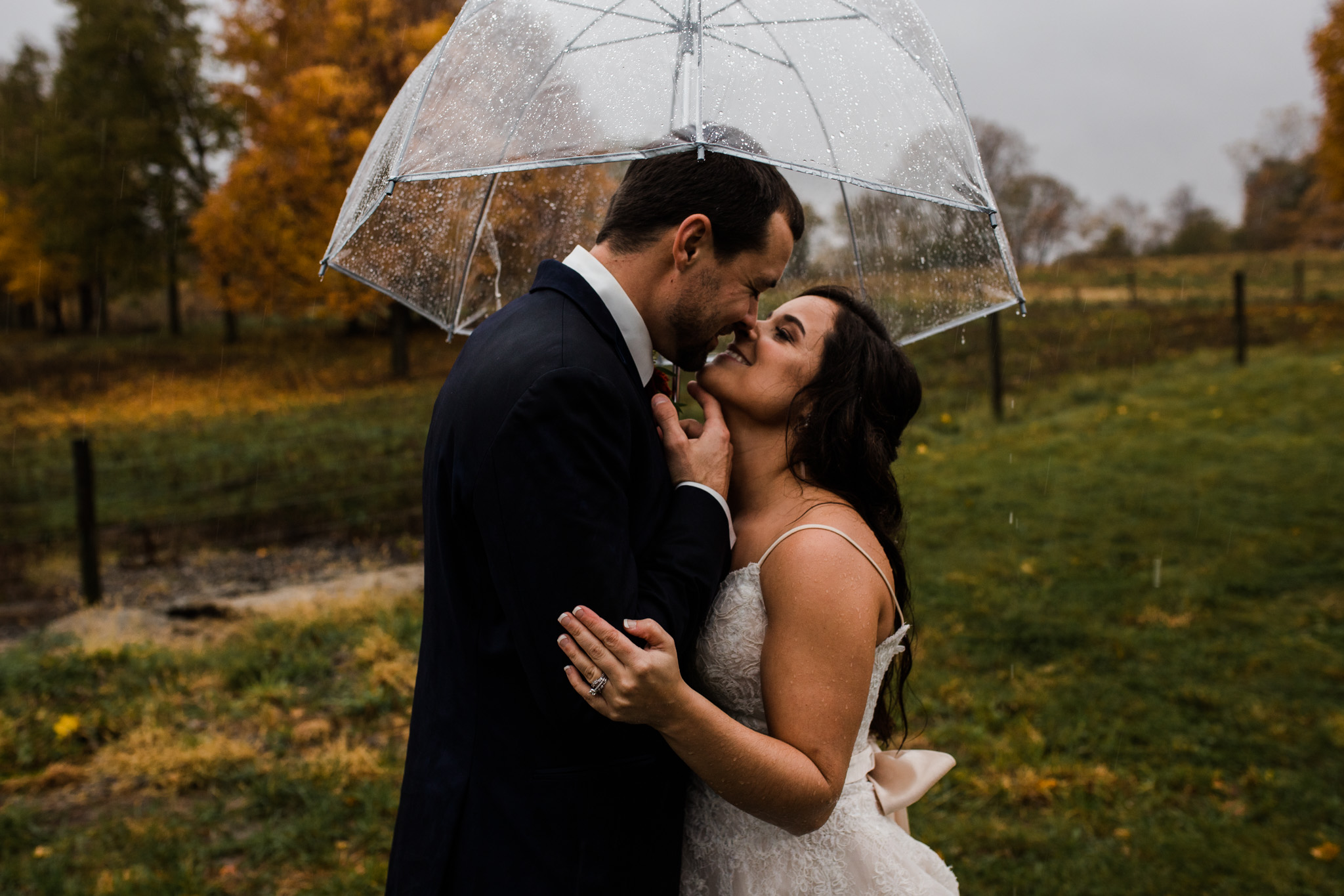 An intimate moment in the rain during this October bison ranch wedding.