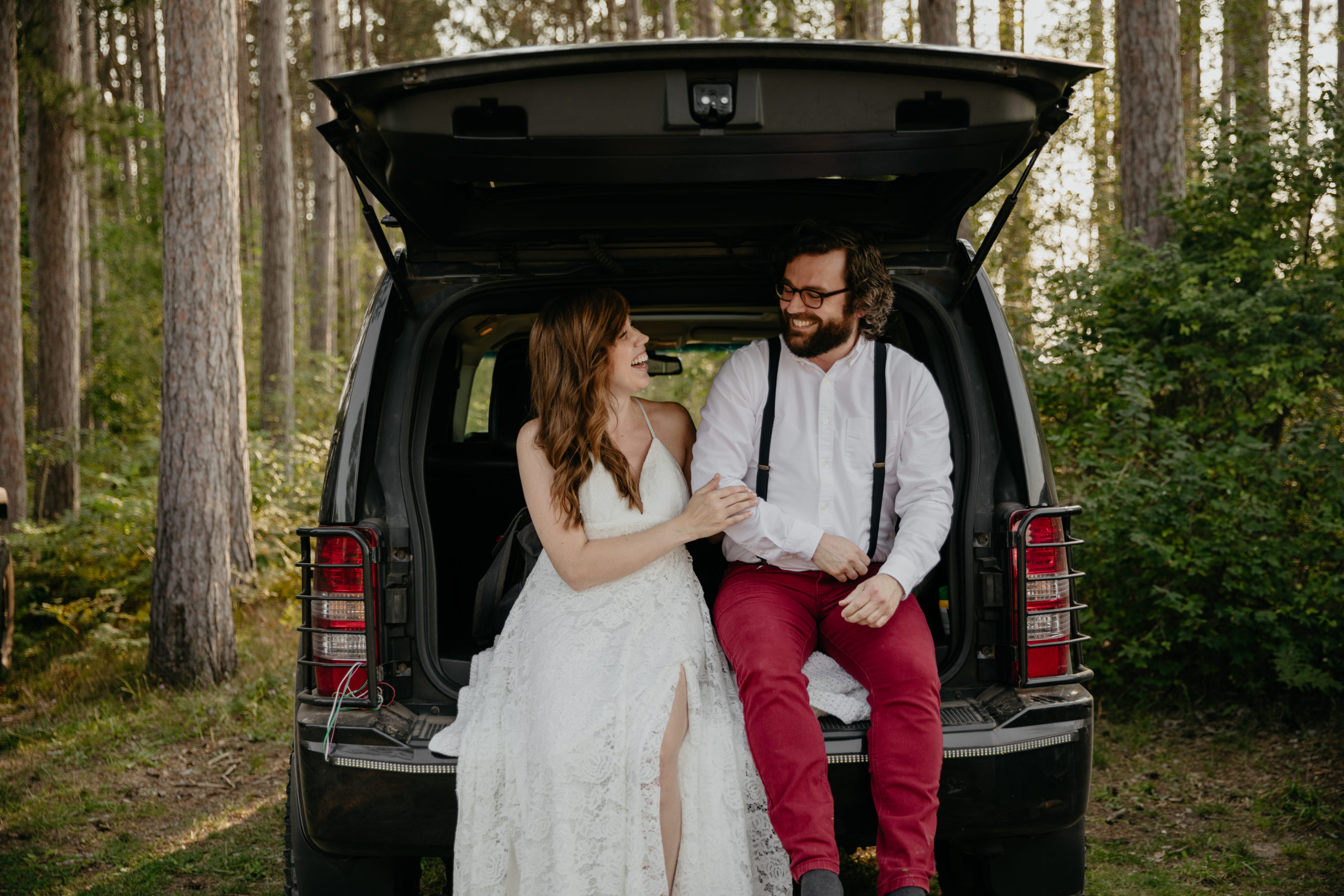 Getting ready together in the back of a jeep for this forest elopement