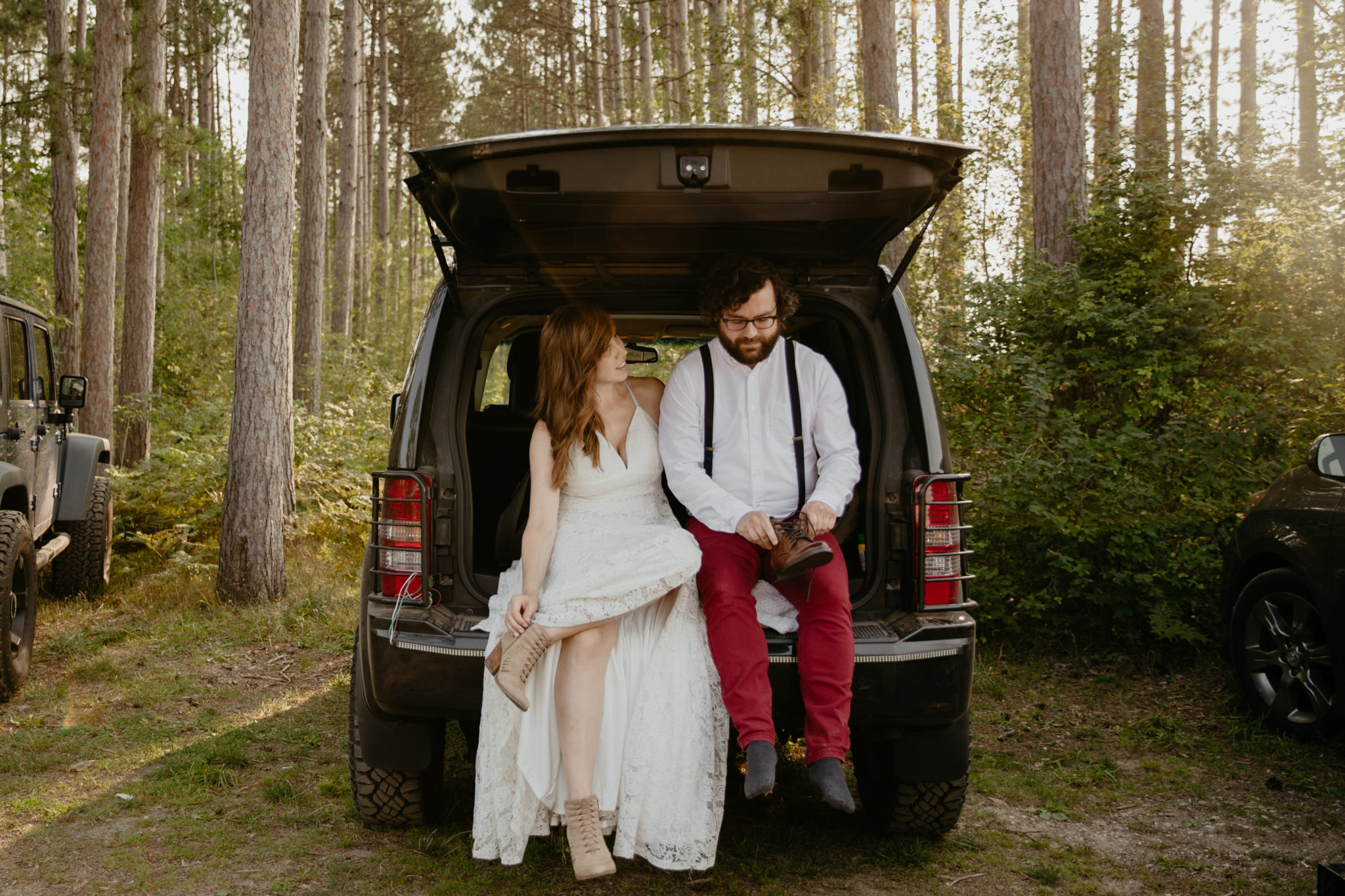 Getting ready together in the back of a jeep for this forest elopement