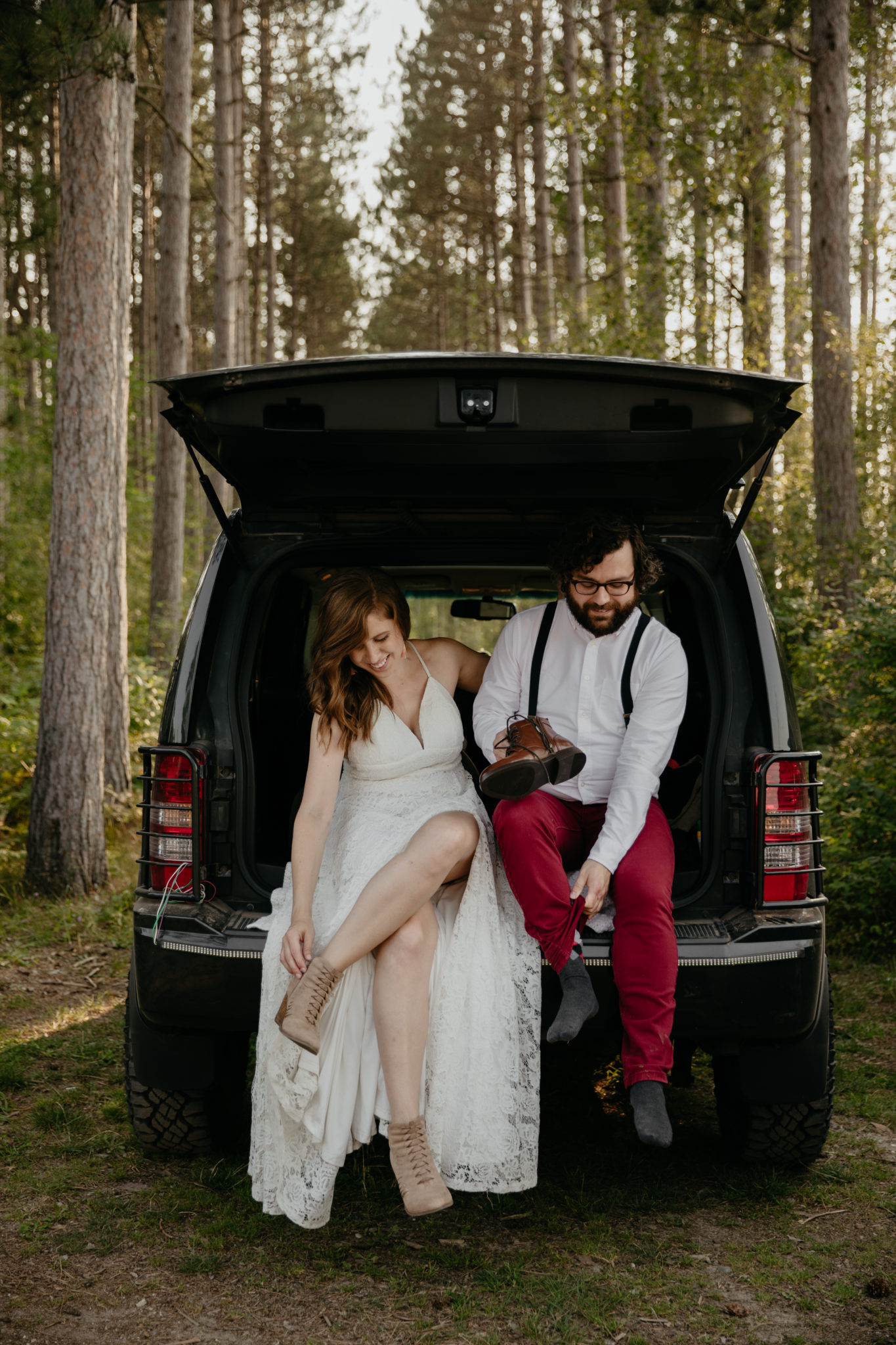 Getting ready together in the back of a jeep for this forest elopement