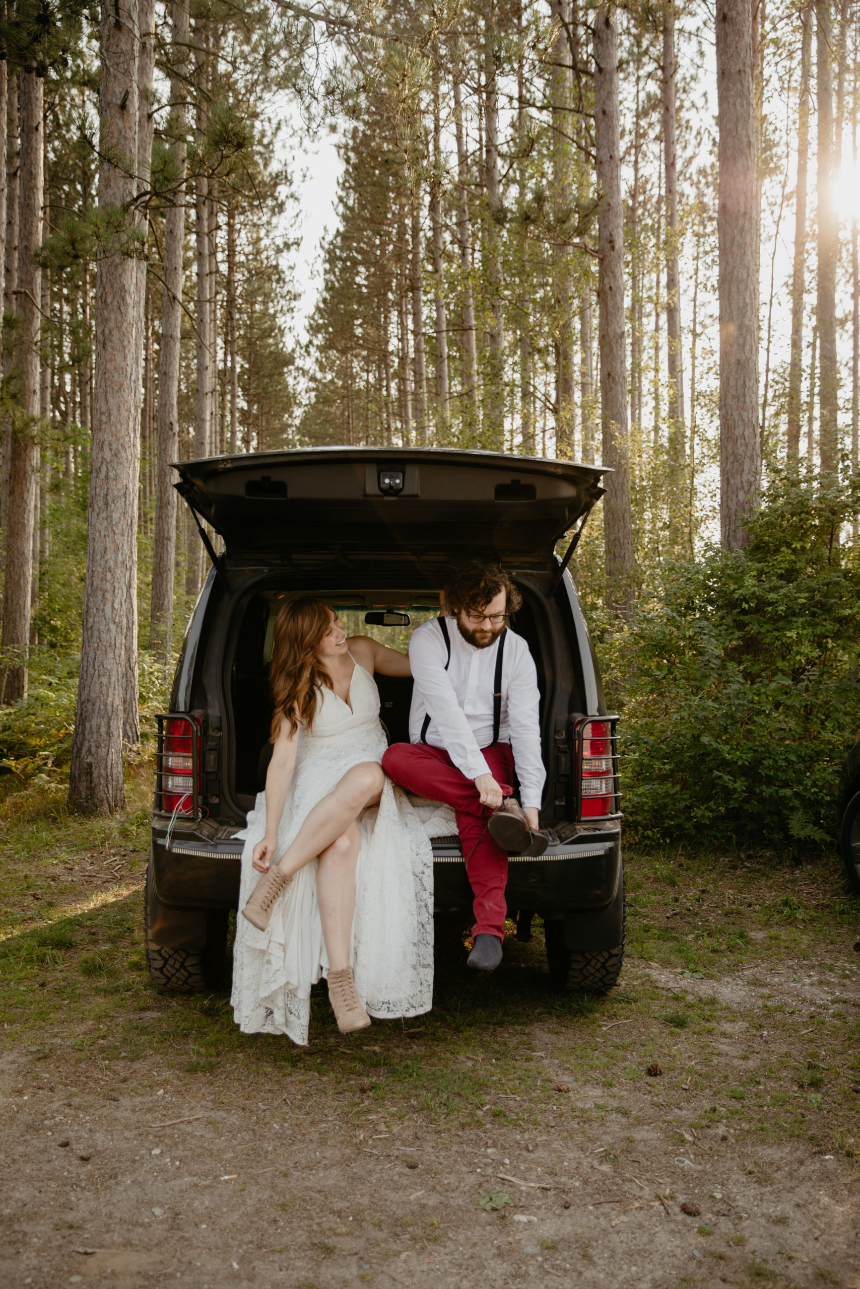 Getting ready together in the back of a jeep for this forest elopement