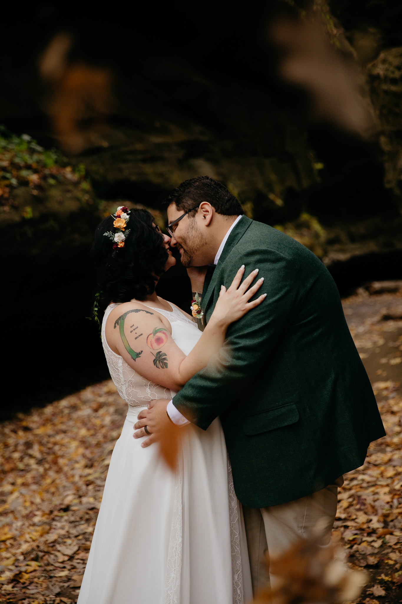 Leaves falling as bride and groom kiss during their fall elopement at Turkey Run State Park