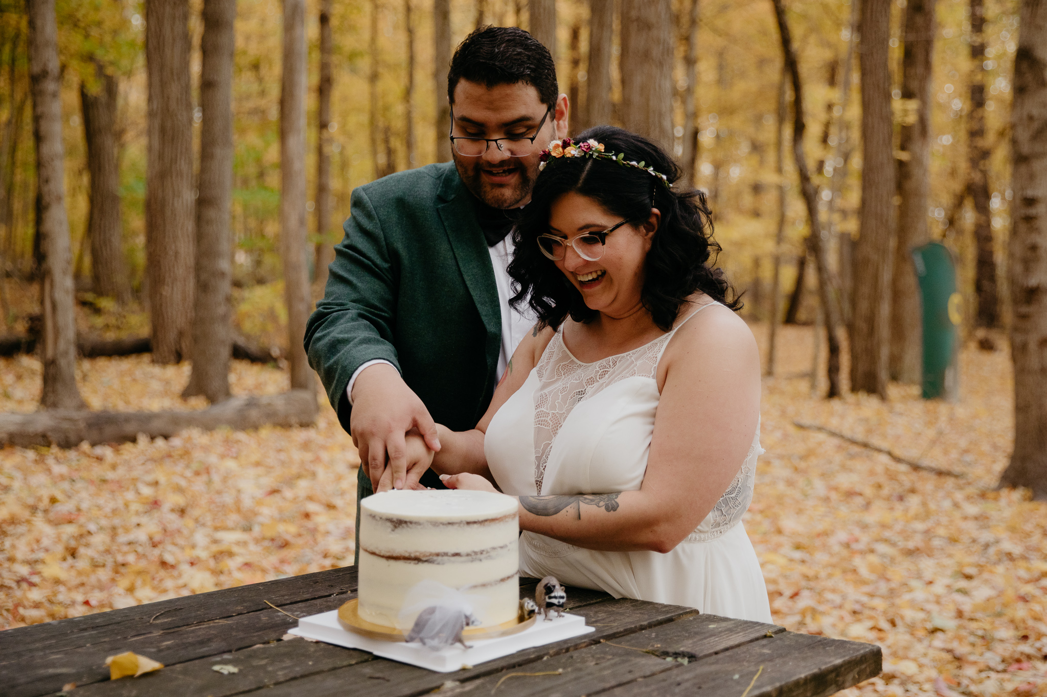 Bride and groom cutting wedding cake at campsite during their autumn Indiana elopement
