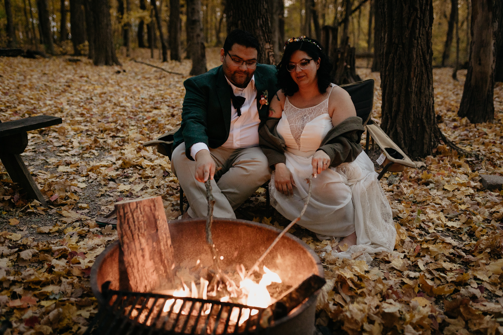 Bride and groom snuggle by a campfire during their fall elopement at Turkey Run State Park