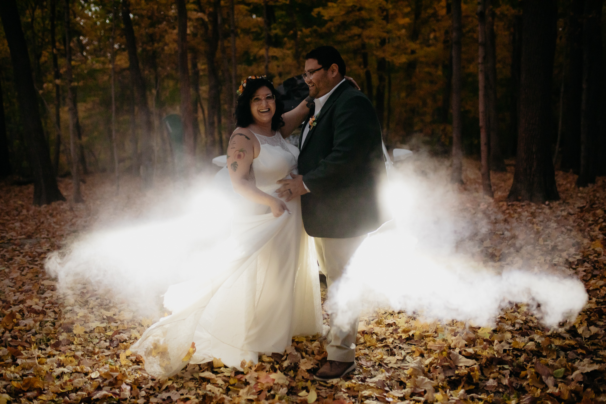 Bride and groom dancing in front of foggy headlights at night to end their fall Indiana Elopement