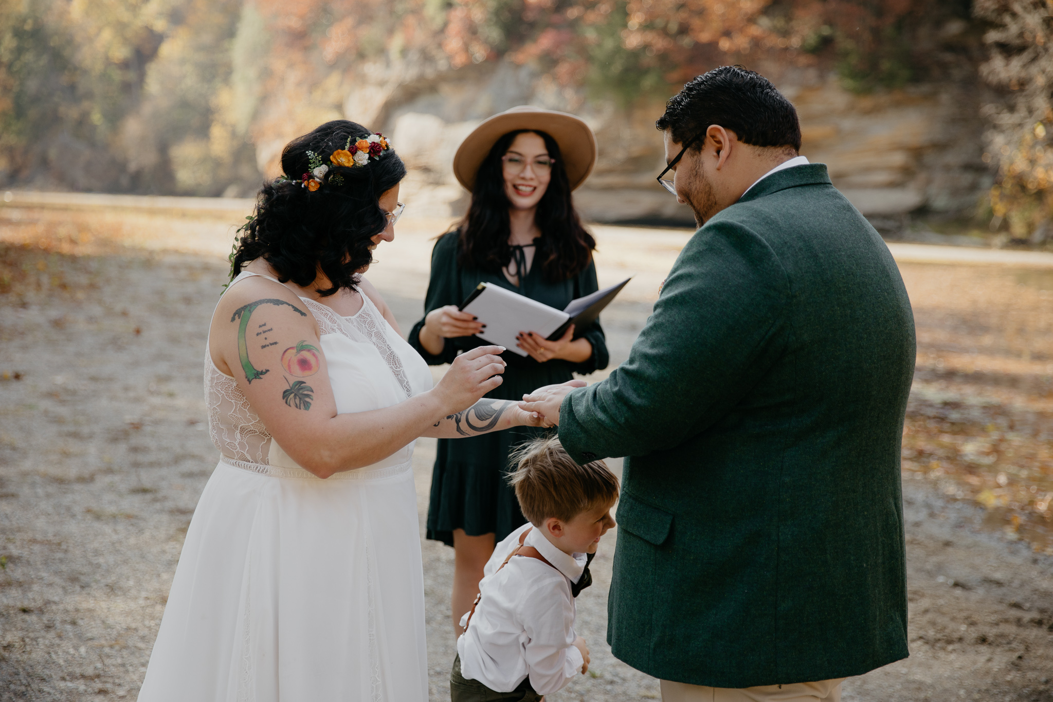 A groom shares his vows with his bride and son at their autumn elopement in Turkey Run State Park, Indiana