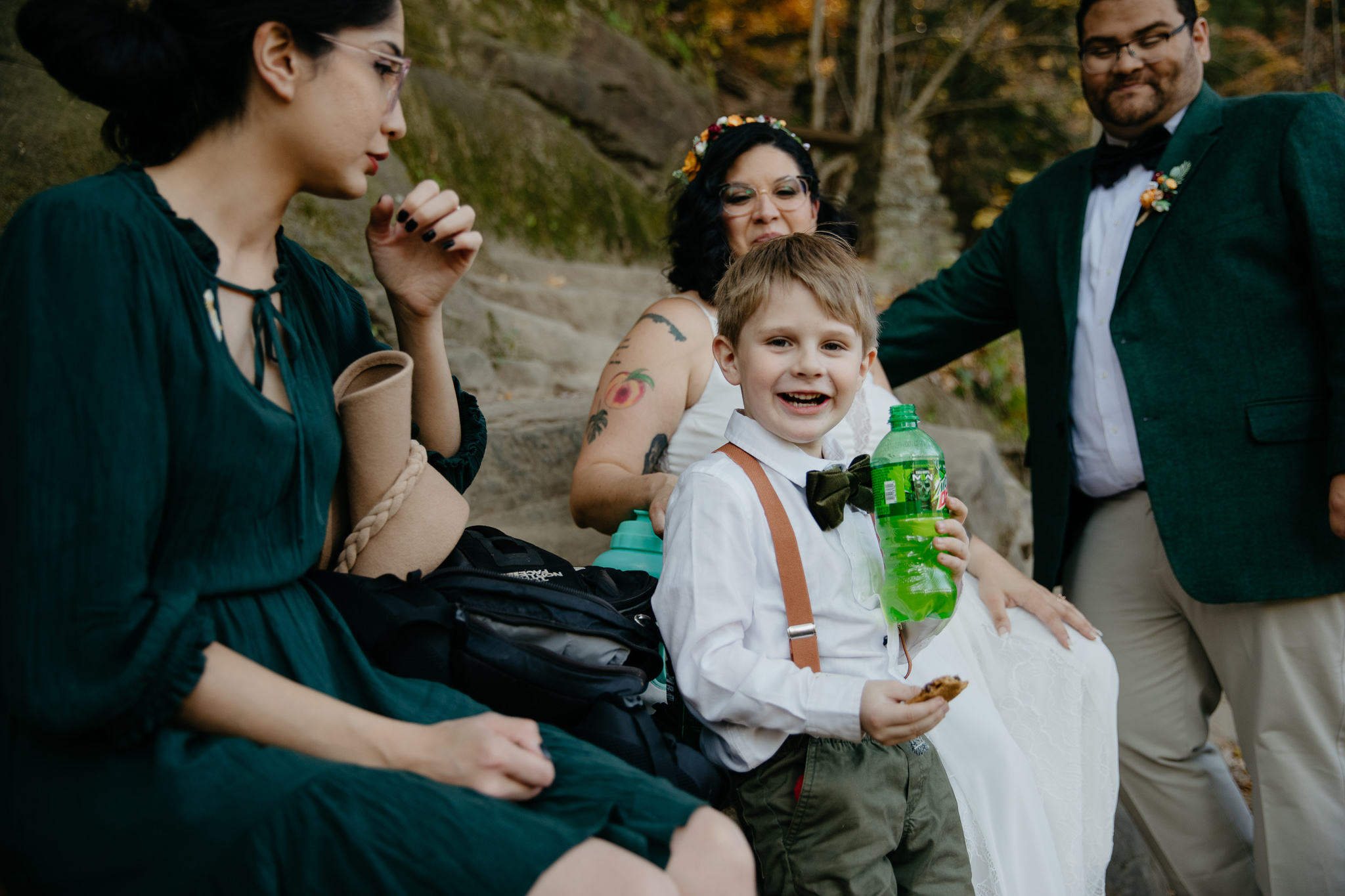A candid moment of a kid eating snacks and drinking soda during a fall elopement