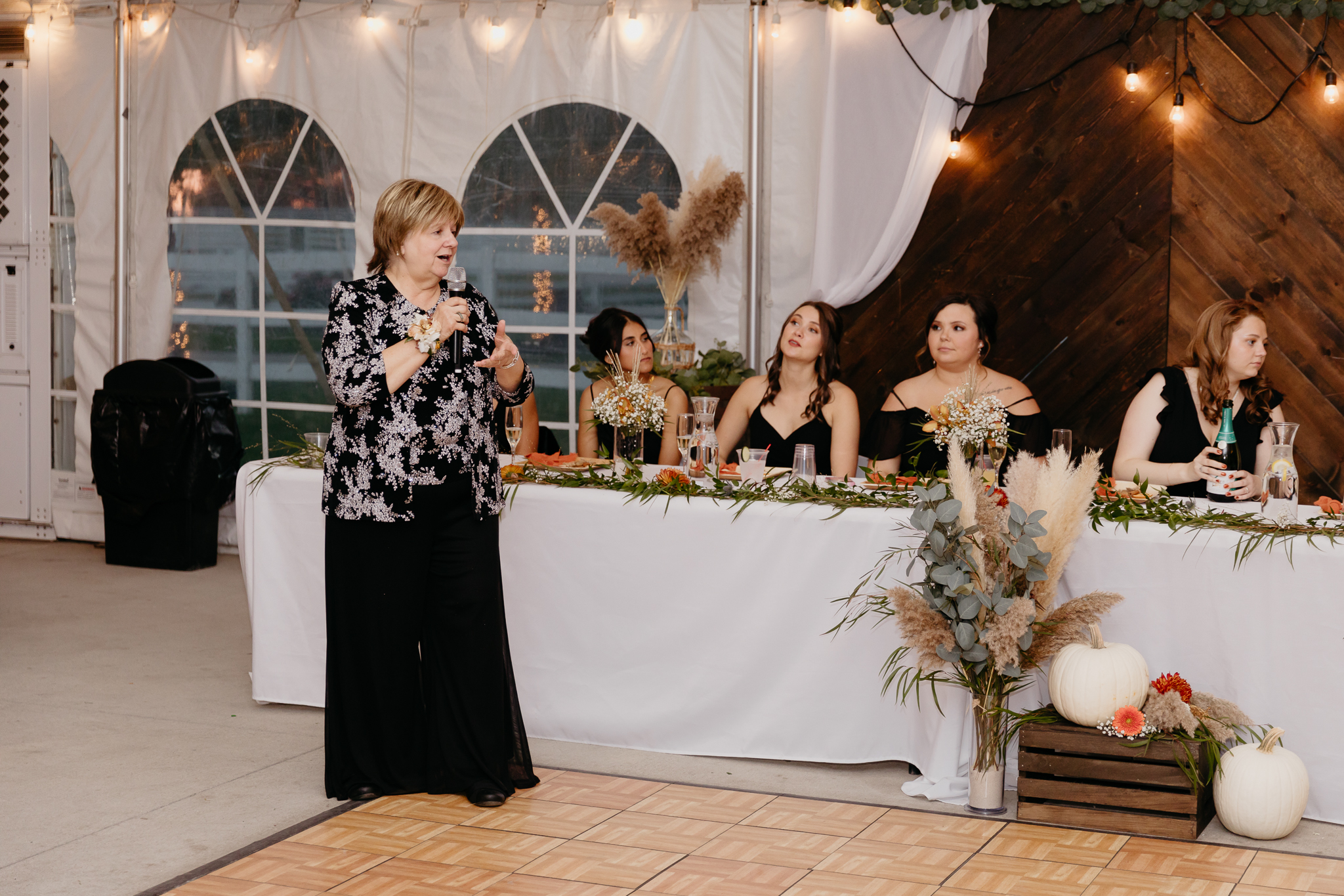 Aunt gives speech standing at white tent wedding