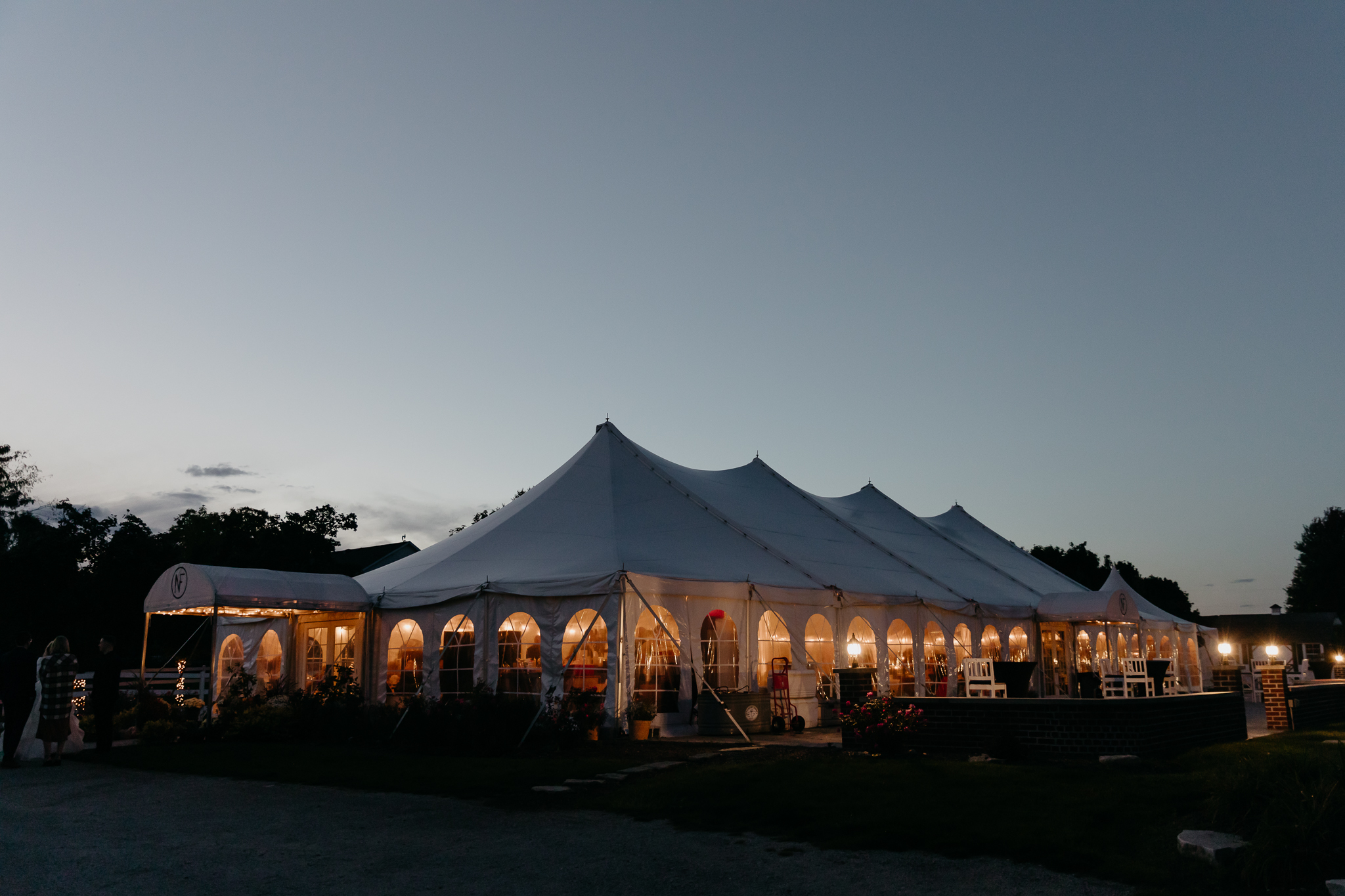 A white tent wedding reception during blue hour, at Northfork Farm, Oswego, IL