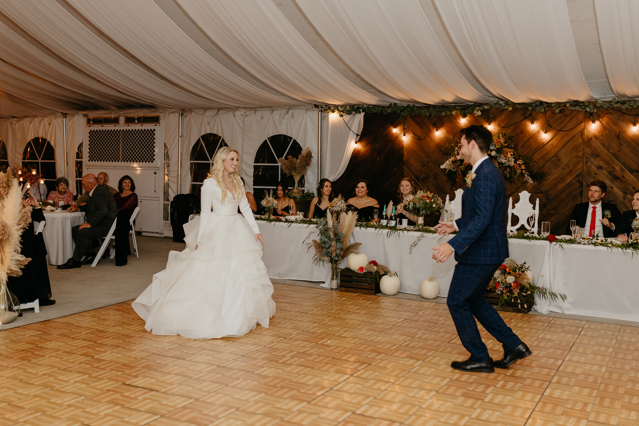 Bride and groom dancing together during their first dance, in a white tent wedding on a horse farm