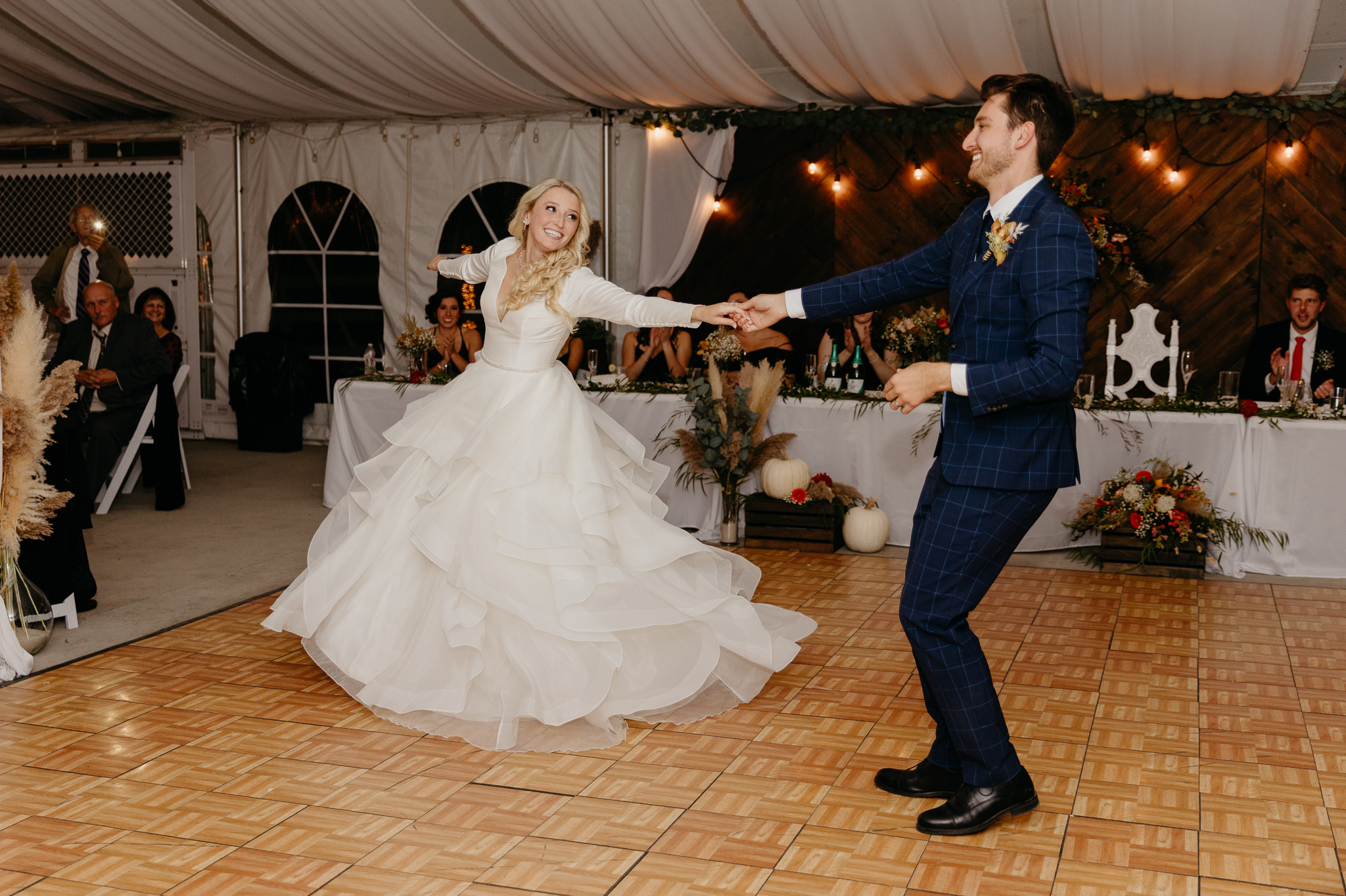 Bride and groom dancing together during their first dance, in a white tent wedding