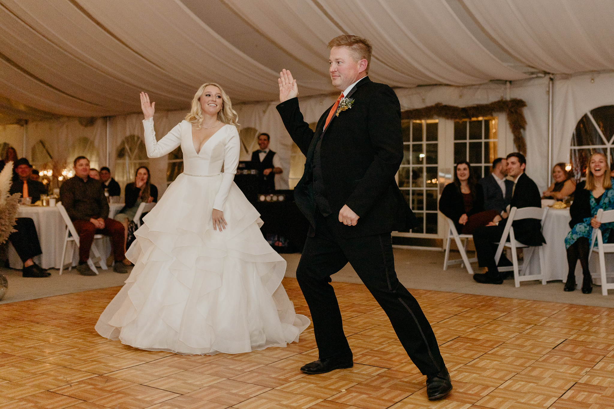 Bride and father dancing together during the father daughter dance, in a white tent wedding