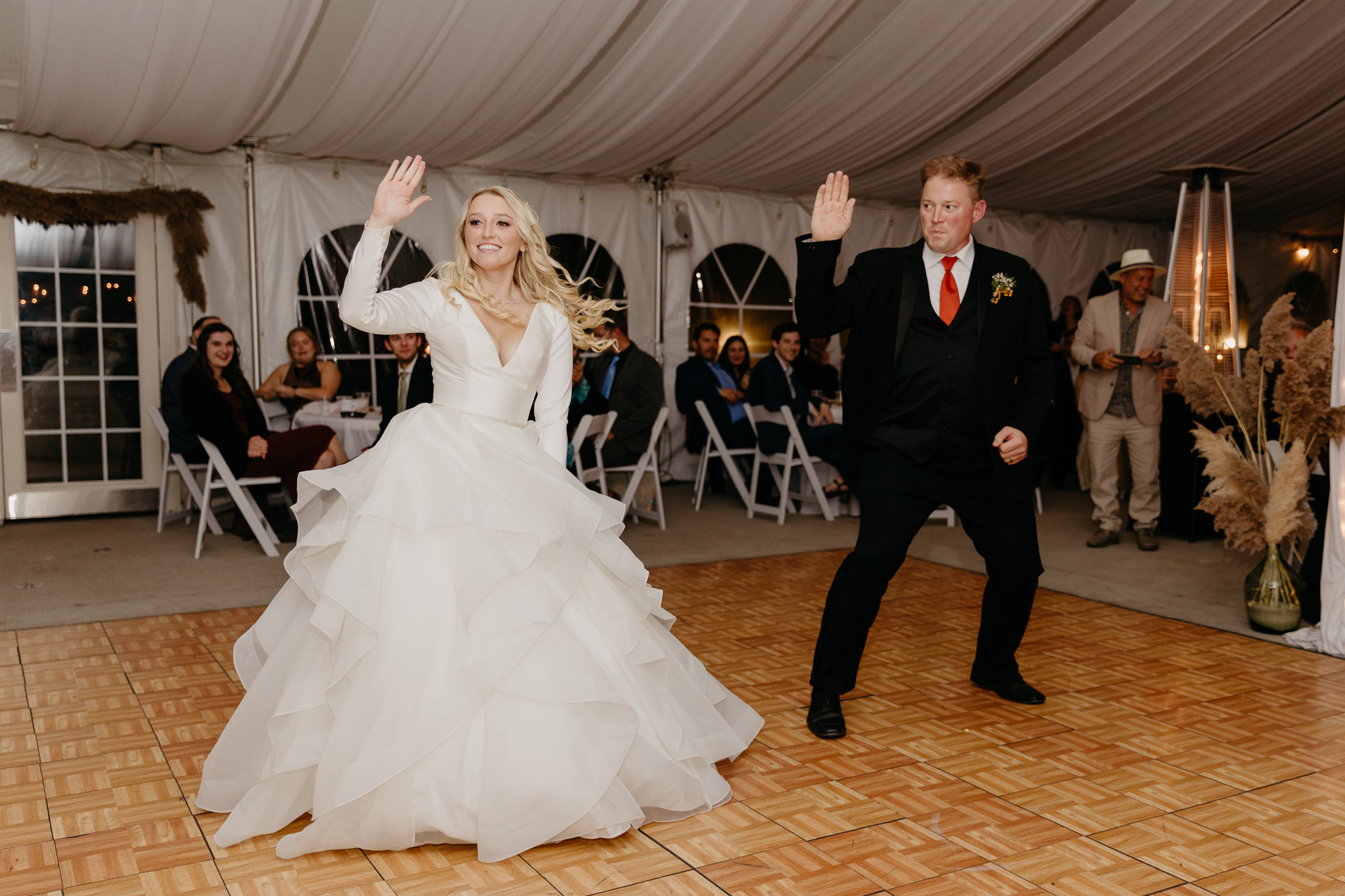 Bride dances with her father on the dancefloor in a white tent wedding