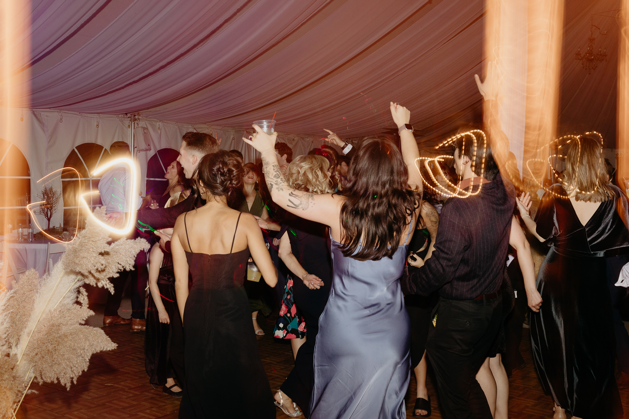 Wedding guests dancing on the dance floor with light trails at their Chicago outdoor tent wedding