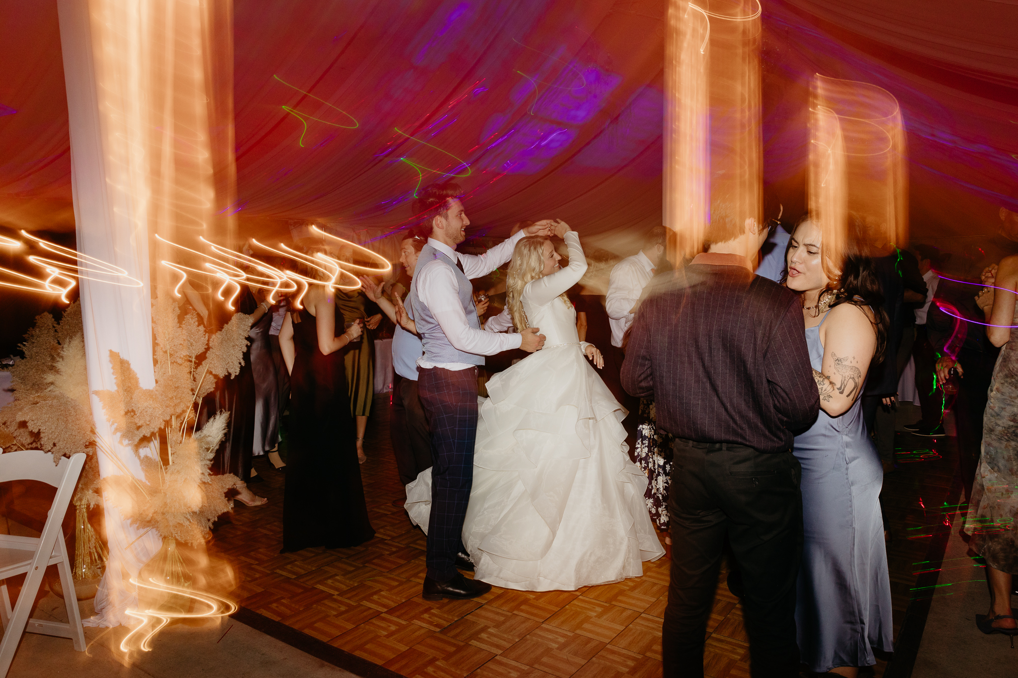 Bride and groom dancing on the dance floor with light trails at their Chicago outdoor tent wedding