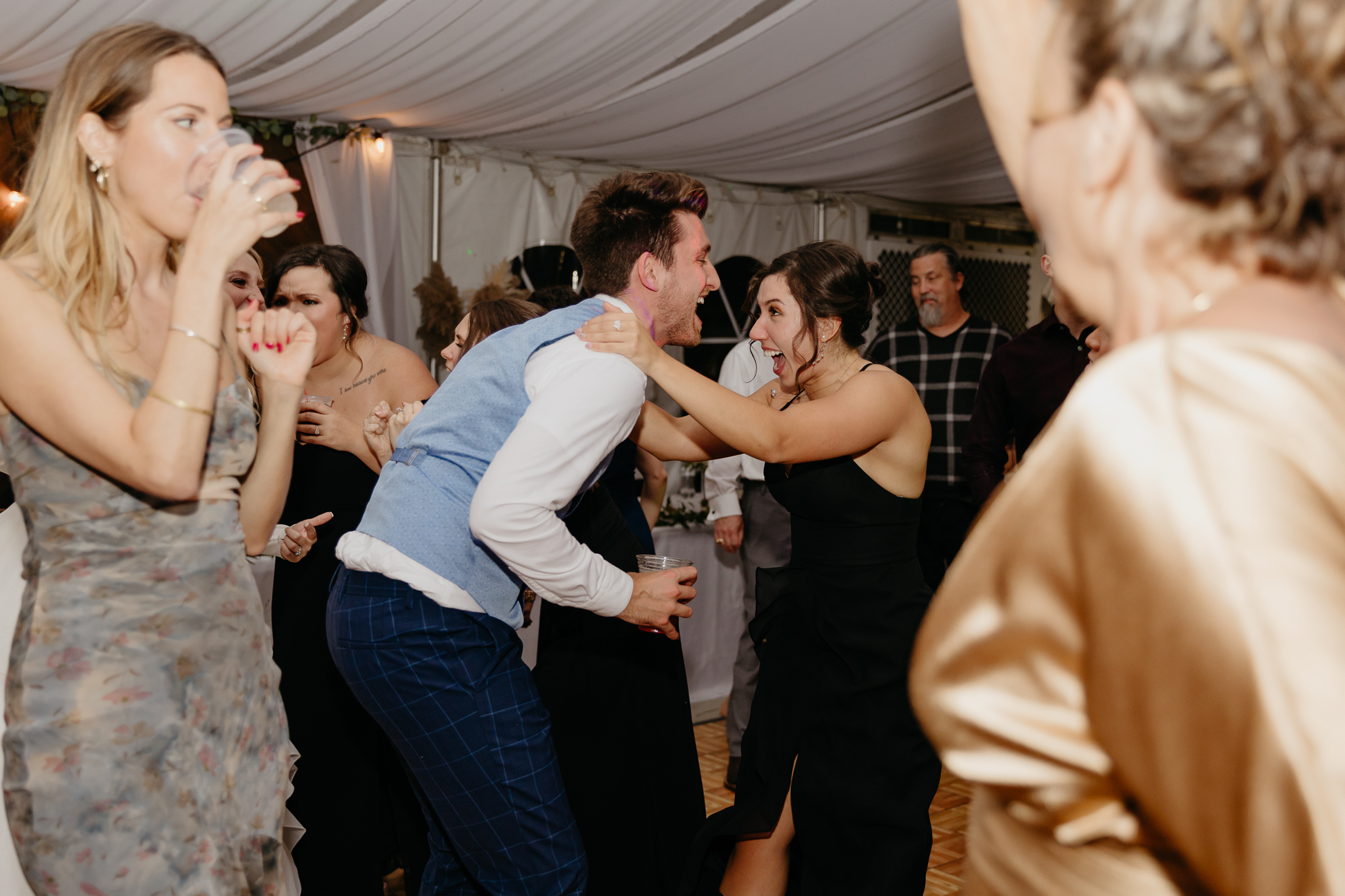 Wedding guests dancing on the dance floor together at a Chicago outdoor tent wedding reception