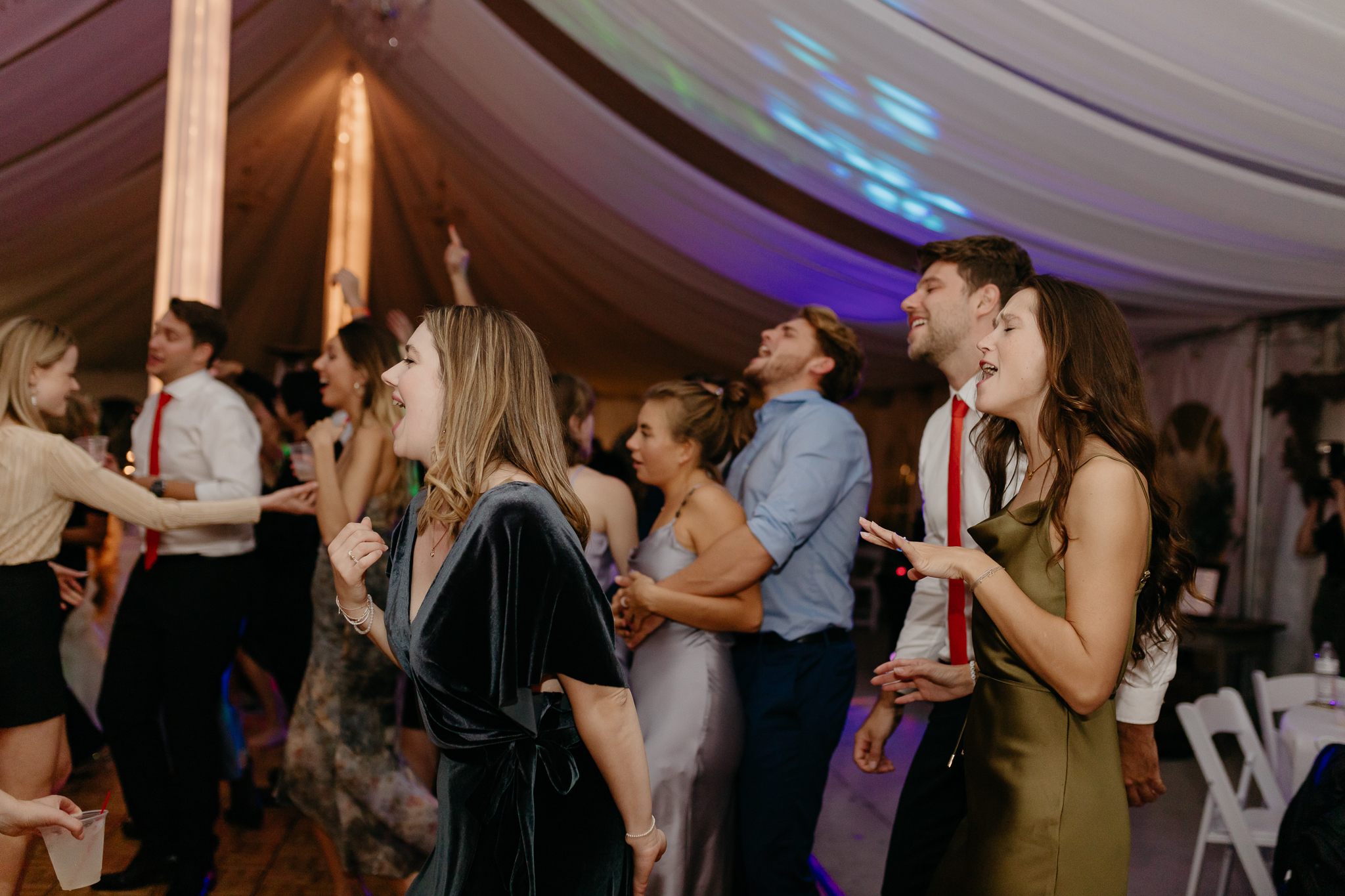Wedding guests dancing on the dance floor together at a Chicago outdoor tent wedding reception