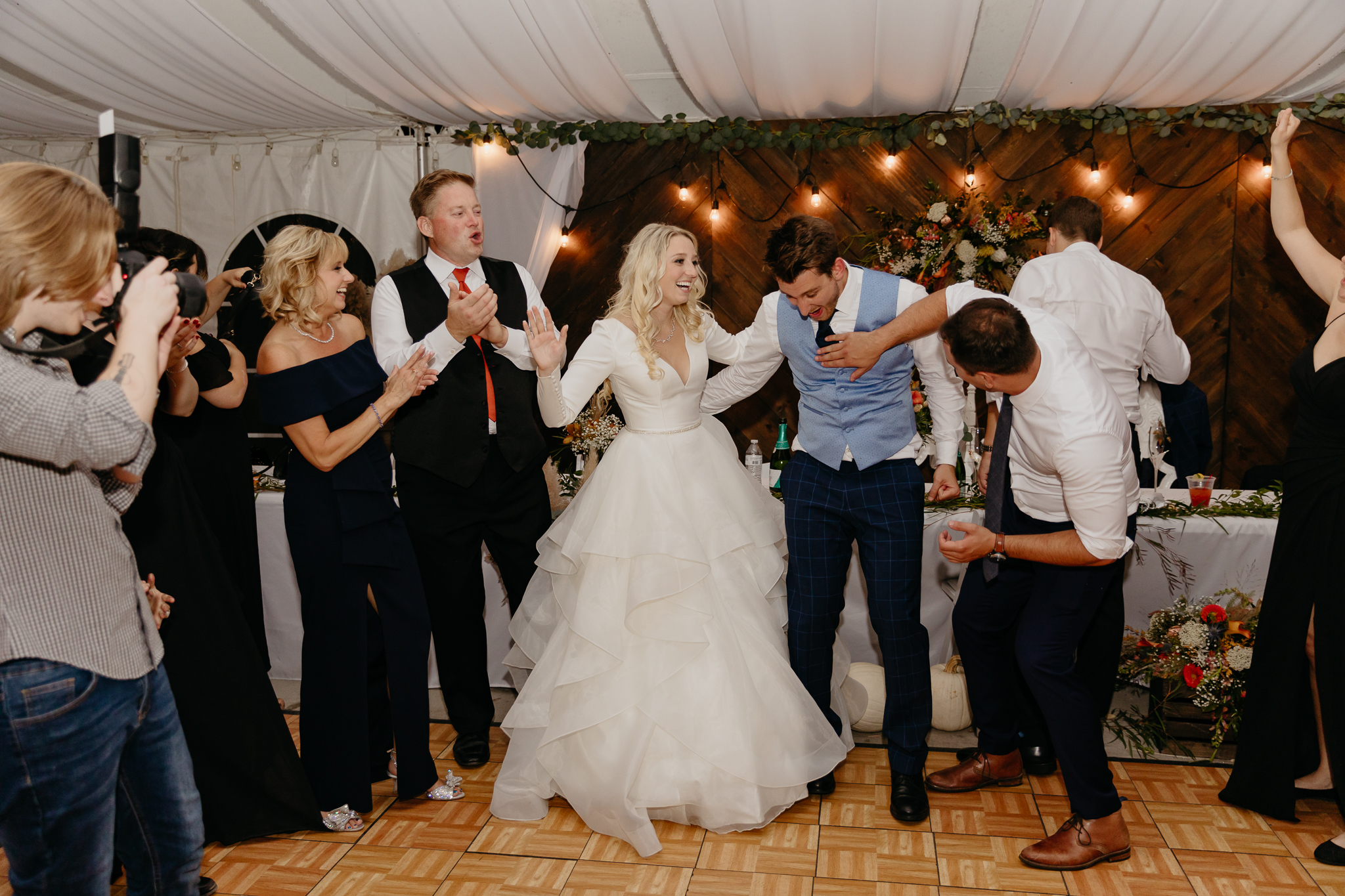 Bride and groom sing and dance with wedding guests on at their tent wedding reception in Chicago