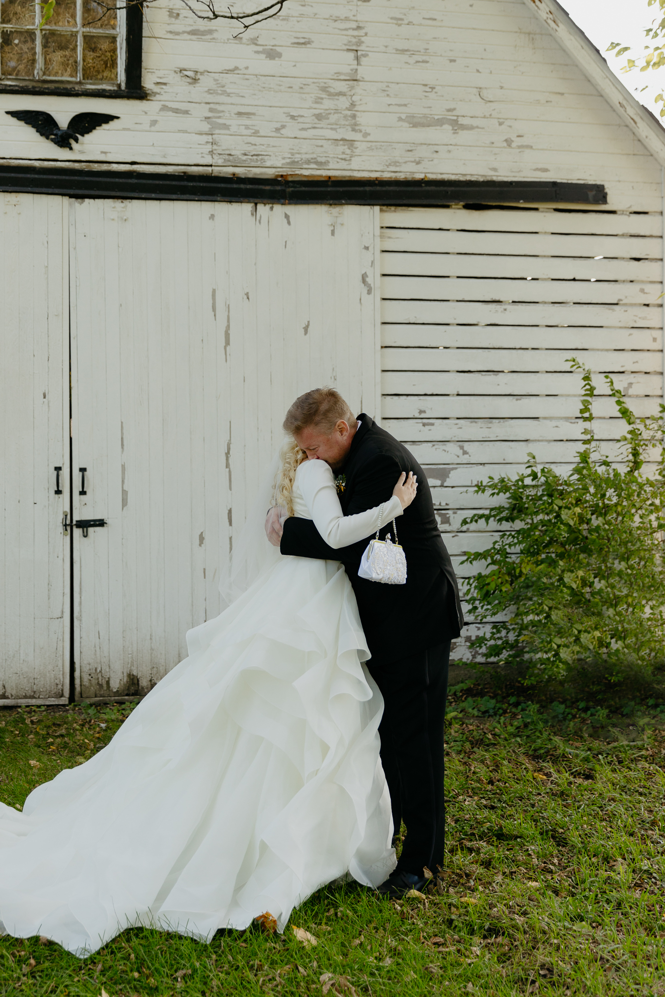 Bride hugs father on shoulder for the first look at her fall wedding at Northfork Farm