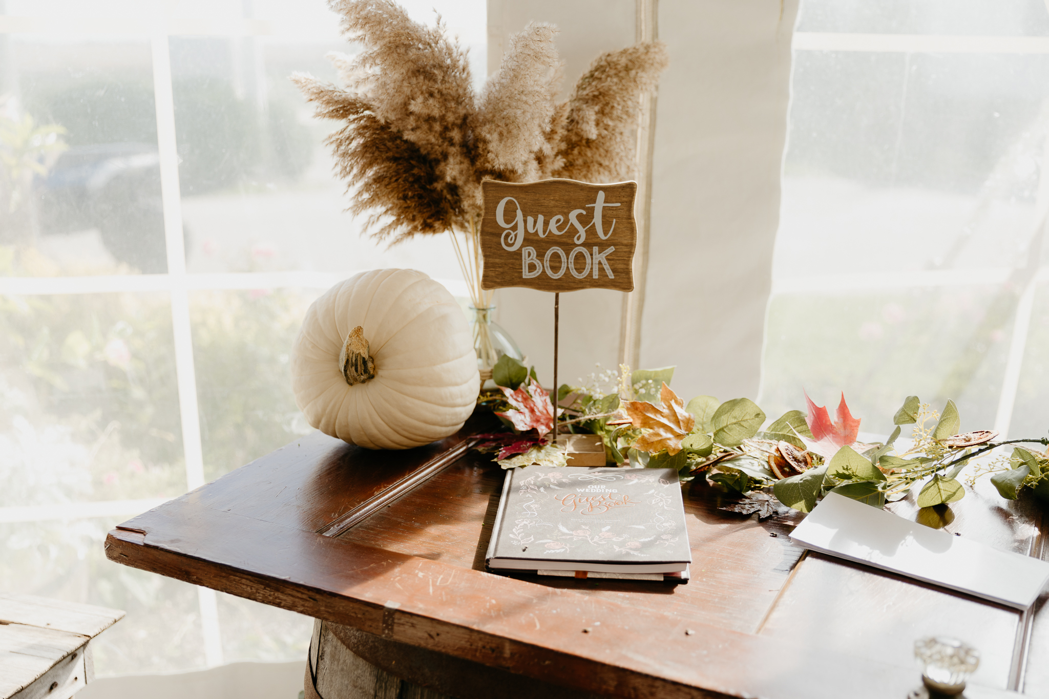 Wedding decorations and guest book on a table for a fall wedding