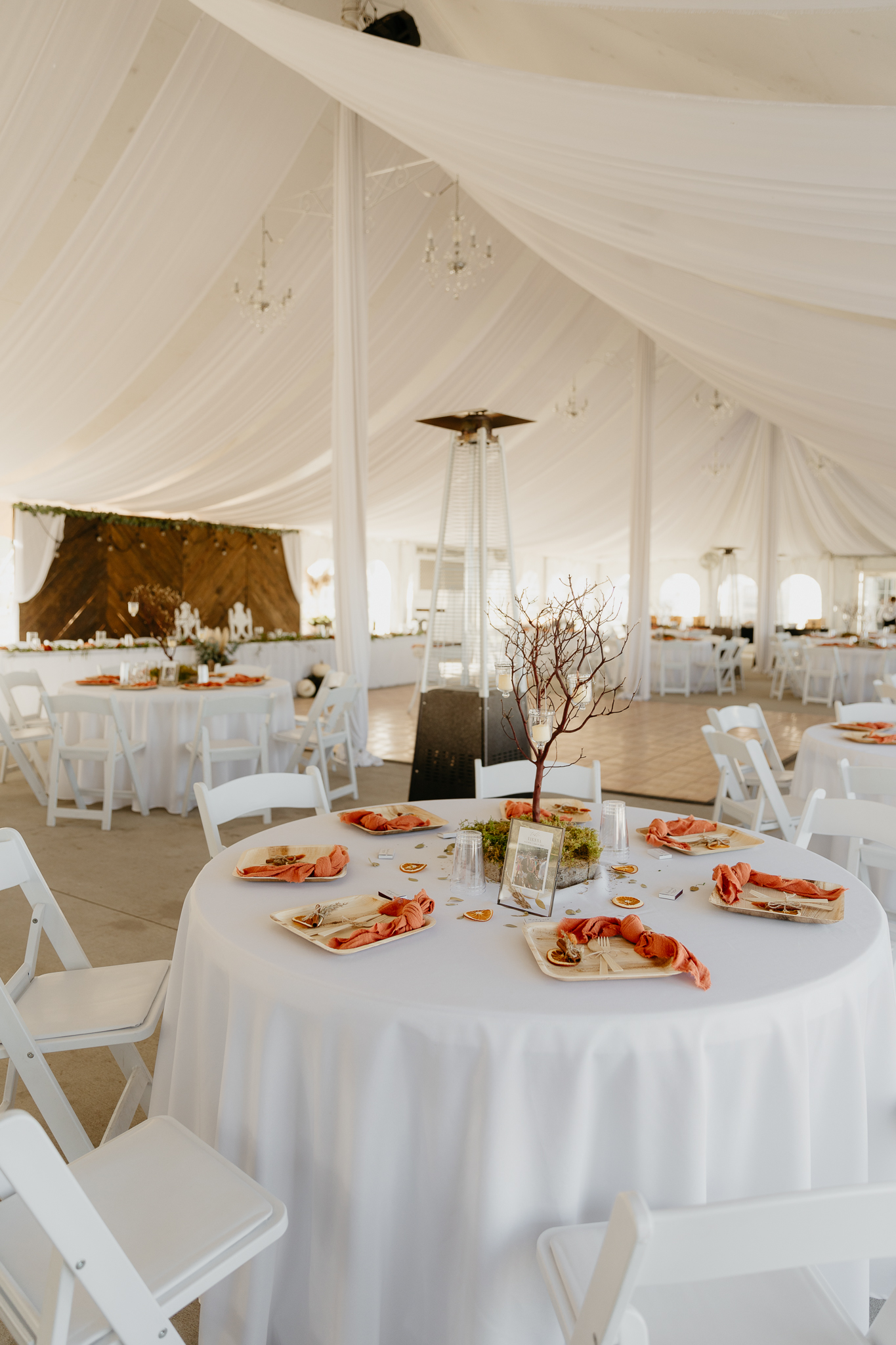 Wedding decorations and tables in a large white tent