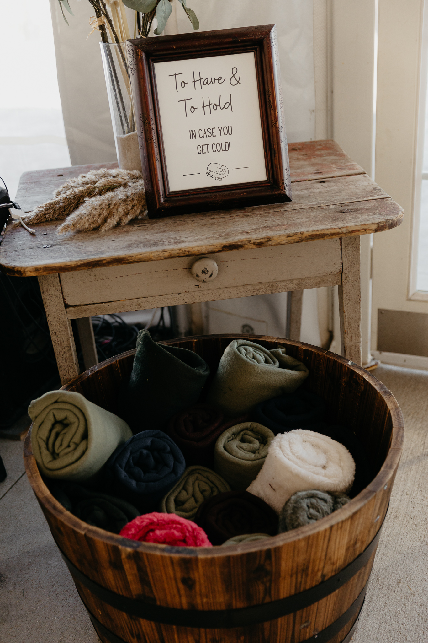 A bucket of blankets and sign that says to have and hold in case you get cold