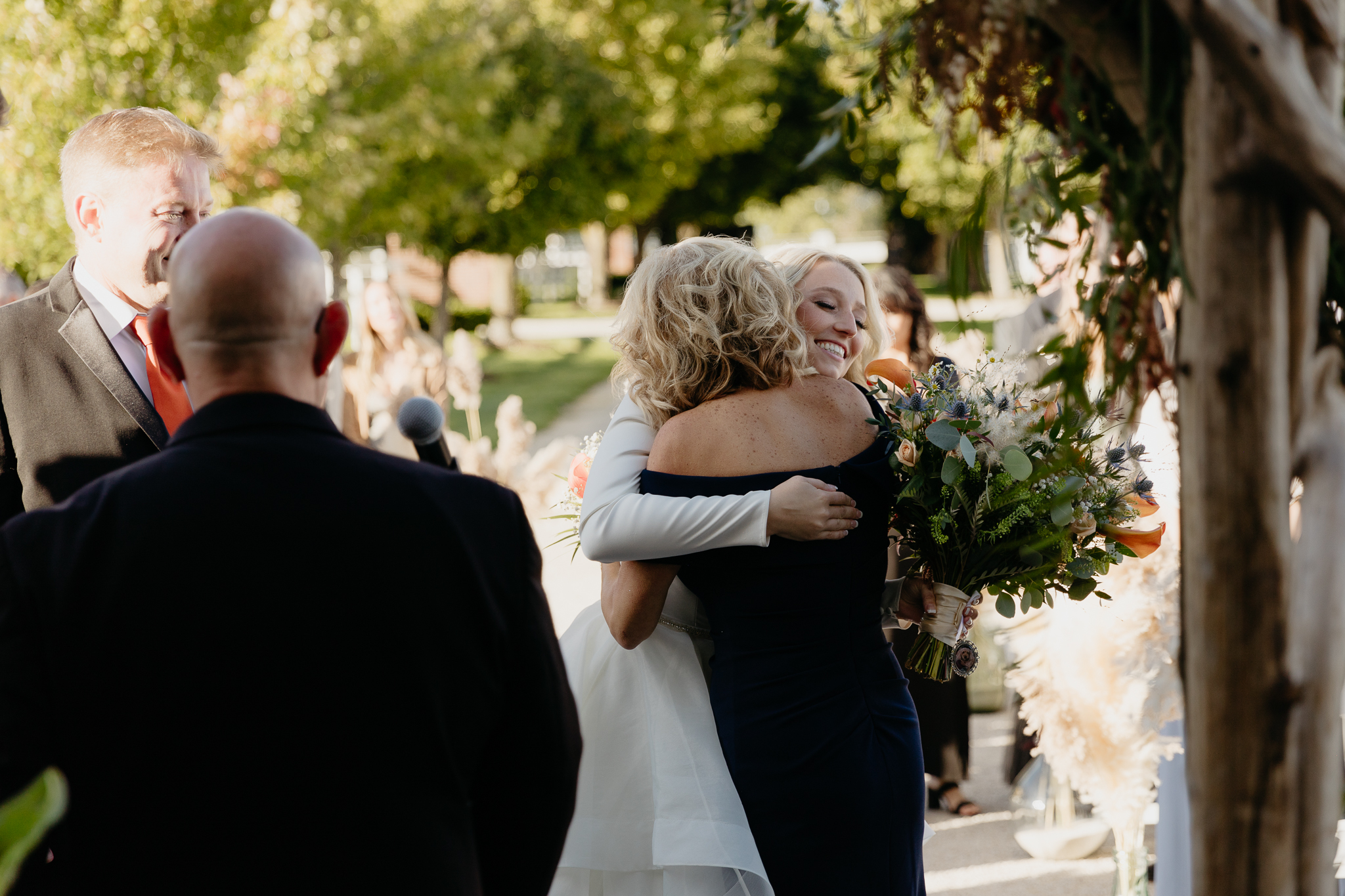 Bride hugs mom at wedding ceremony
