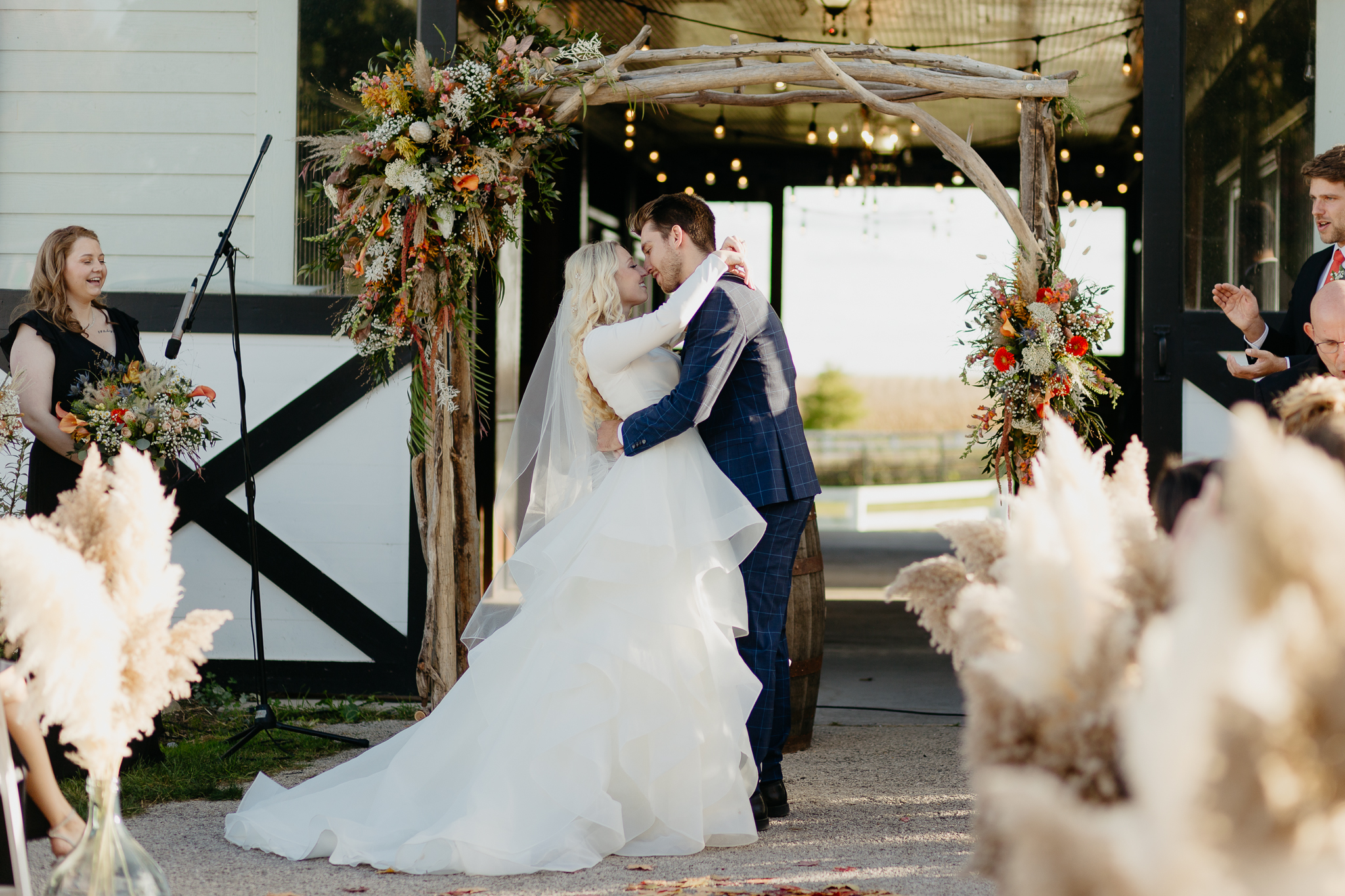 Bride and Groom's first kiss at the altar of their outdoor horse farm wedding in Oswego