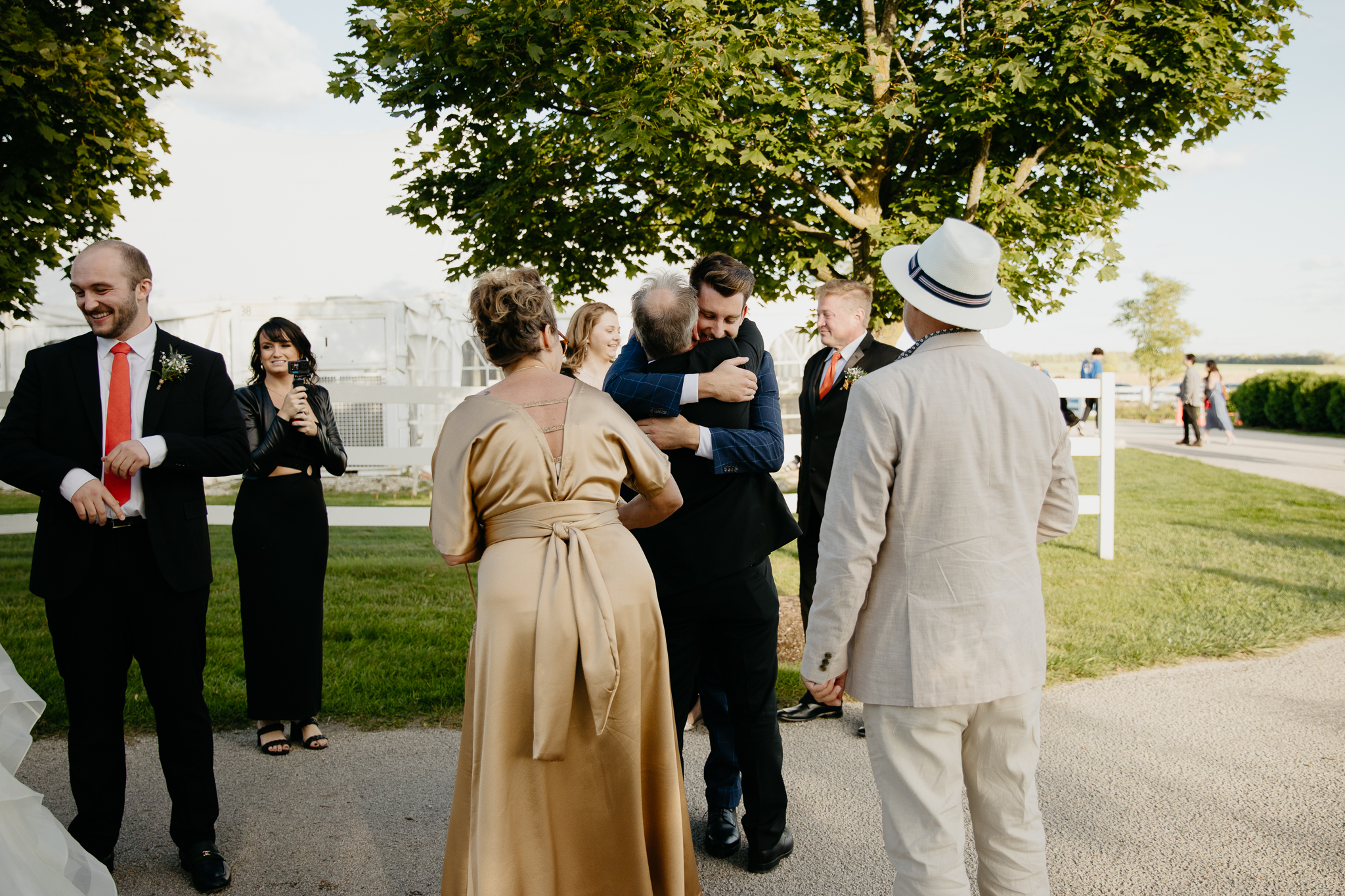 Wedding guests hugging each other and bride and groom after an outdoor wedding ceremony at Northfork Farm