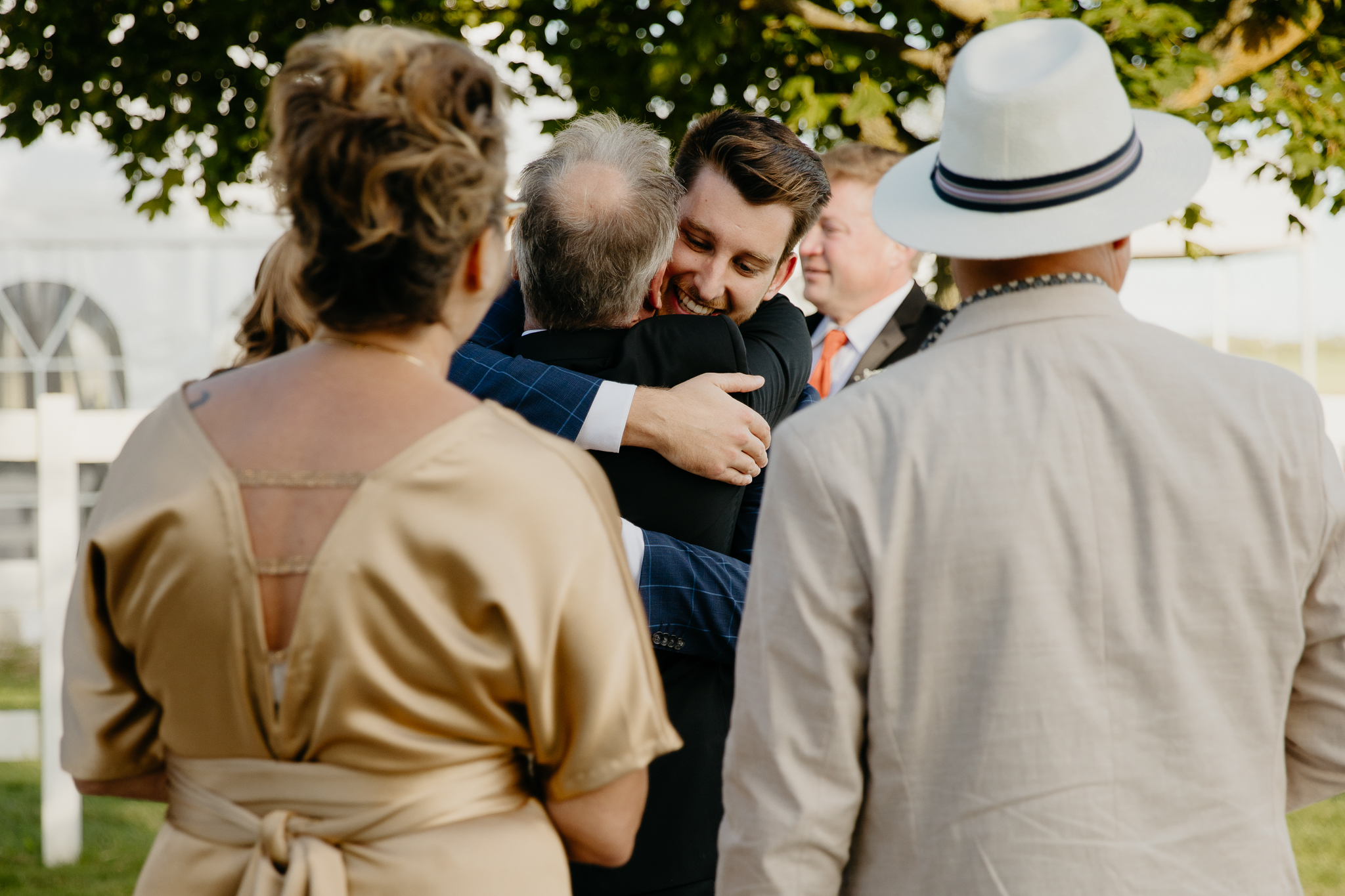 Wedding guests hugging each other and bride and groom after an outdoor wedding ceremony at Northfork Farm