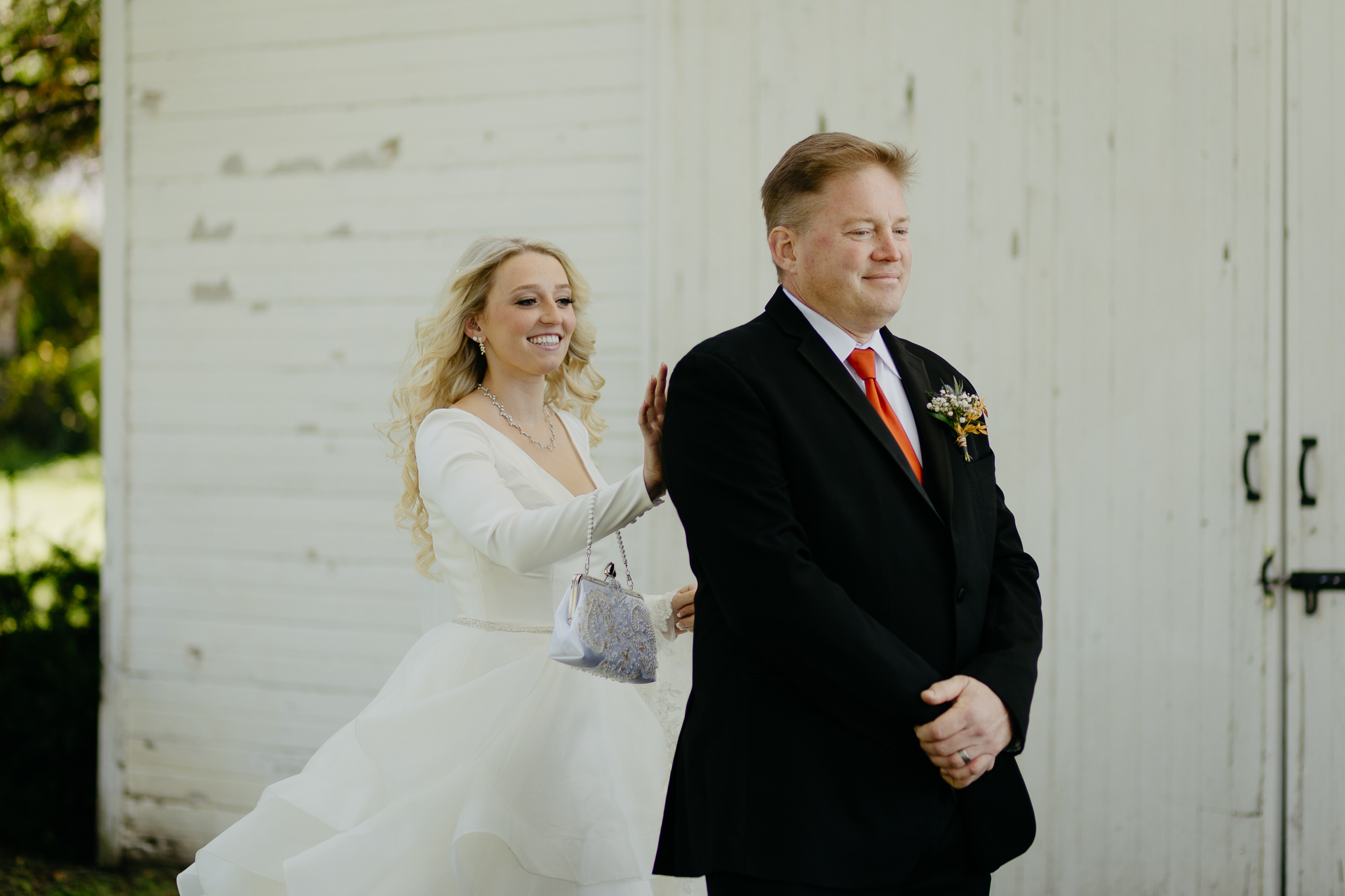 Bride taps father on shoulder for the first look at her fall wedding at Northfork Farm