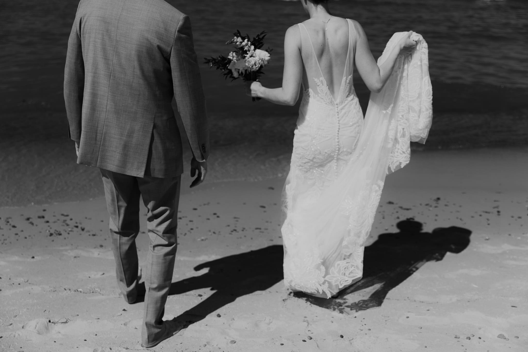 Bride and groom running along the shore of Lake Michigan during their elopement at Warren Dunes State Park