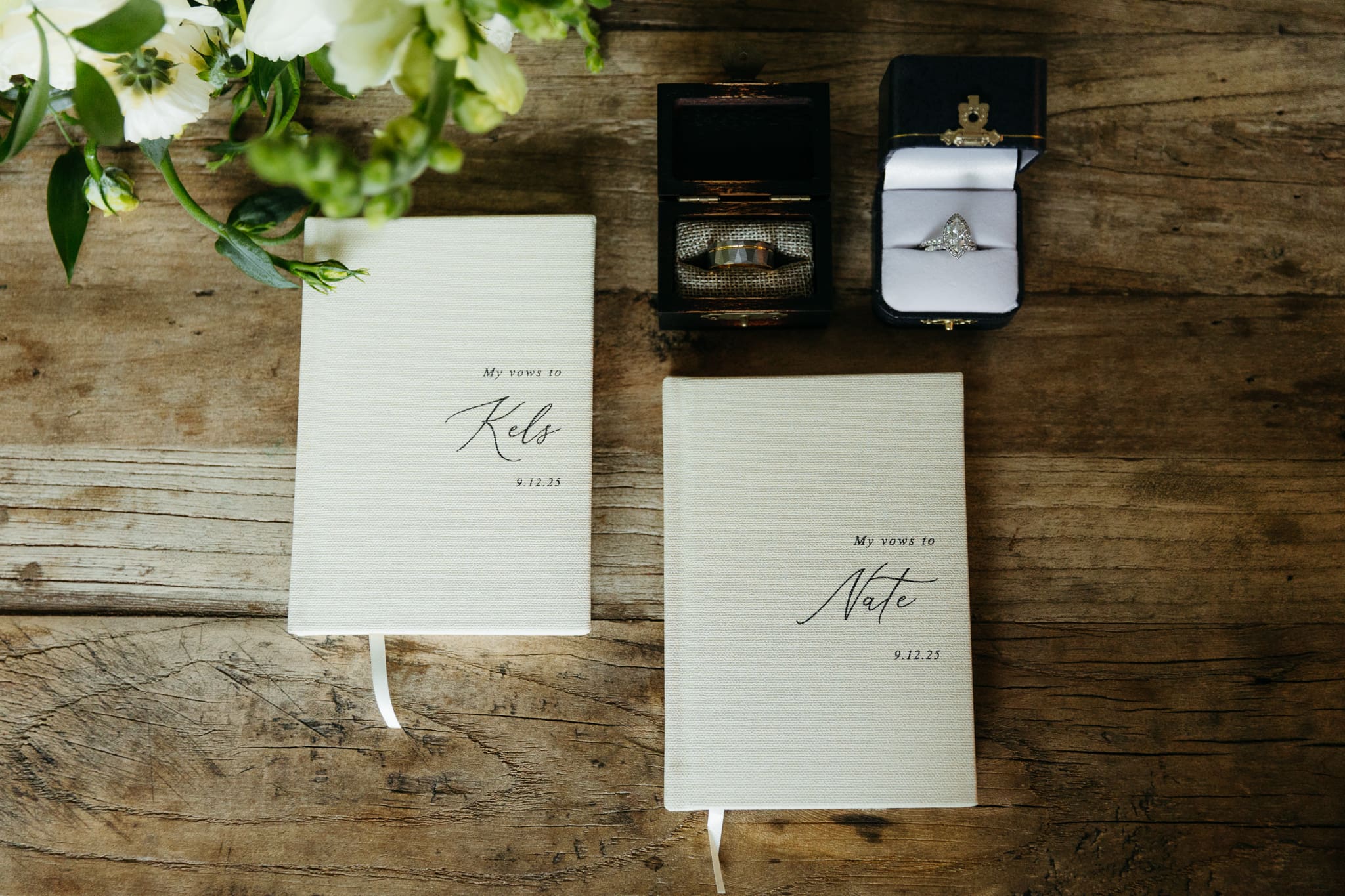 Wedding vow books with wedding rings and bouquet of flowers for a beach elopement at Warren Dunes
