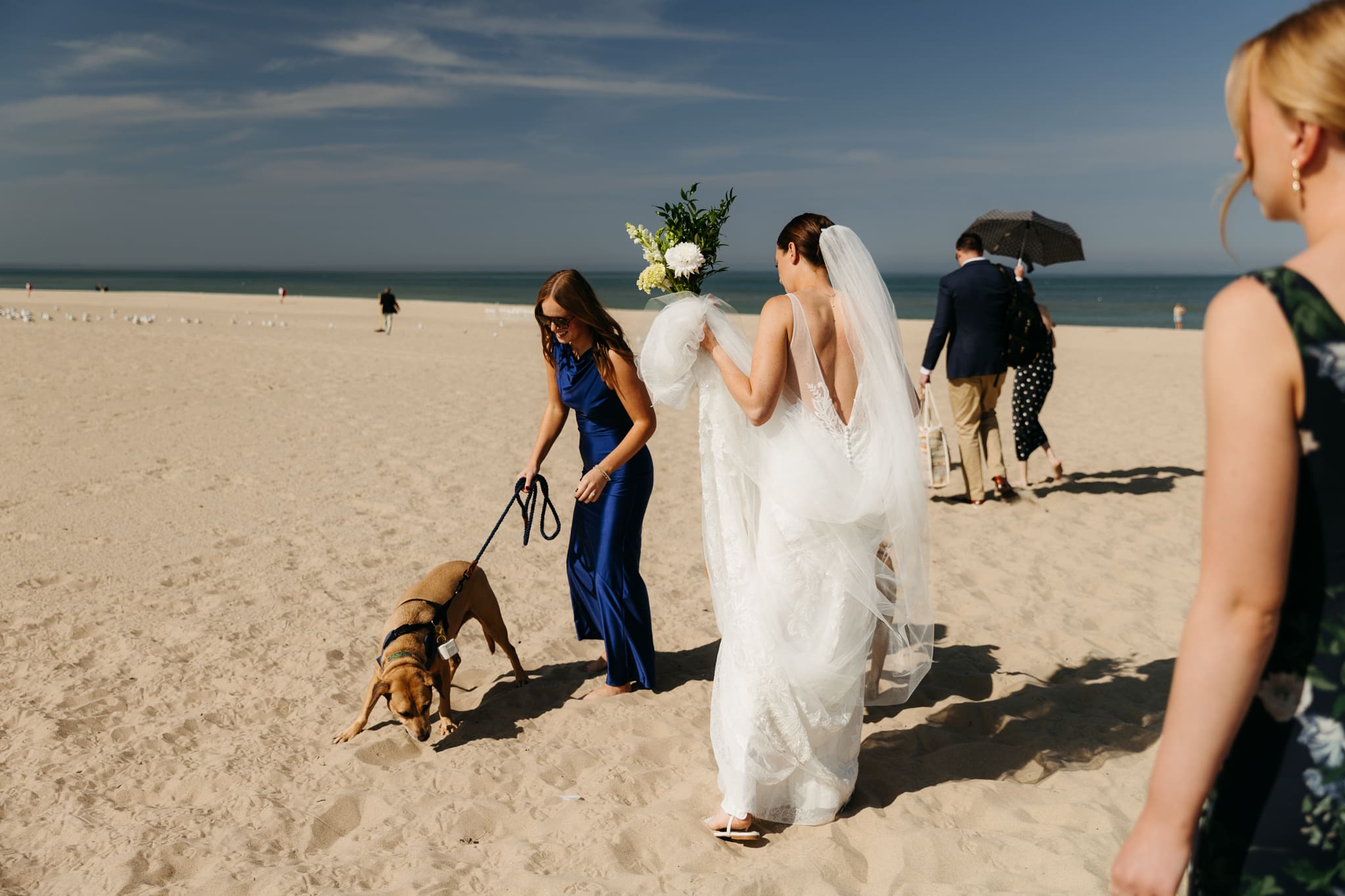 Family and friends walking along the beach towards the wedding ceremony spot at Warren Dunes State Park in Michigan