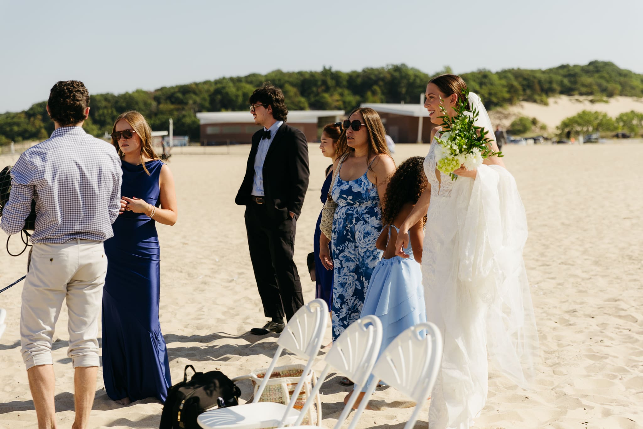 Family and friends hang out and talk on the beach at Warren Dunes State Park, while waiting for a wedding ceremony to begin