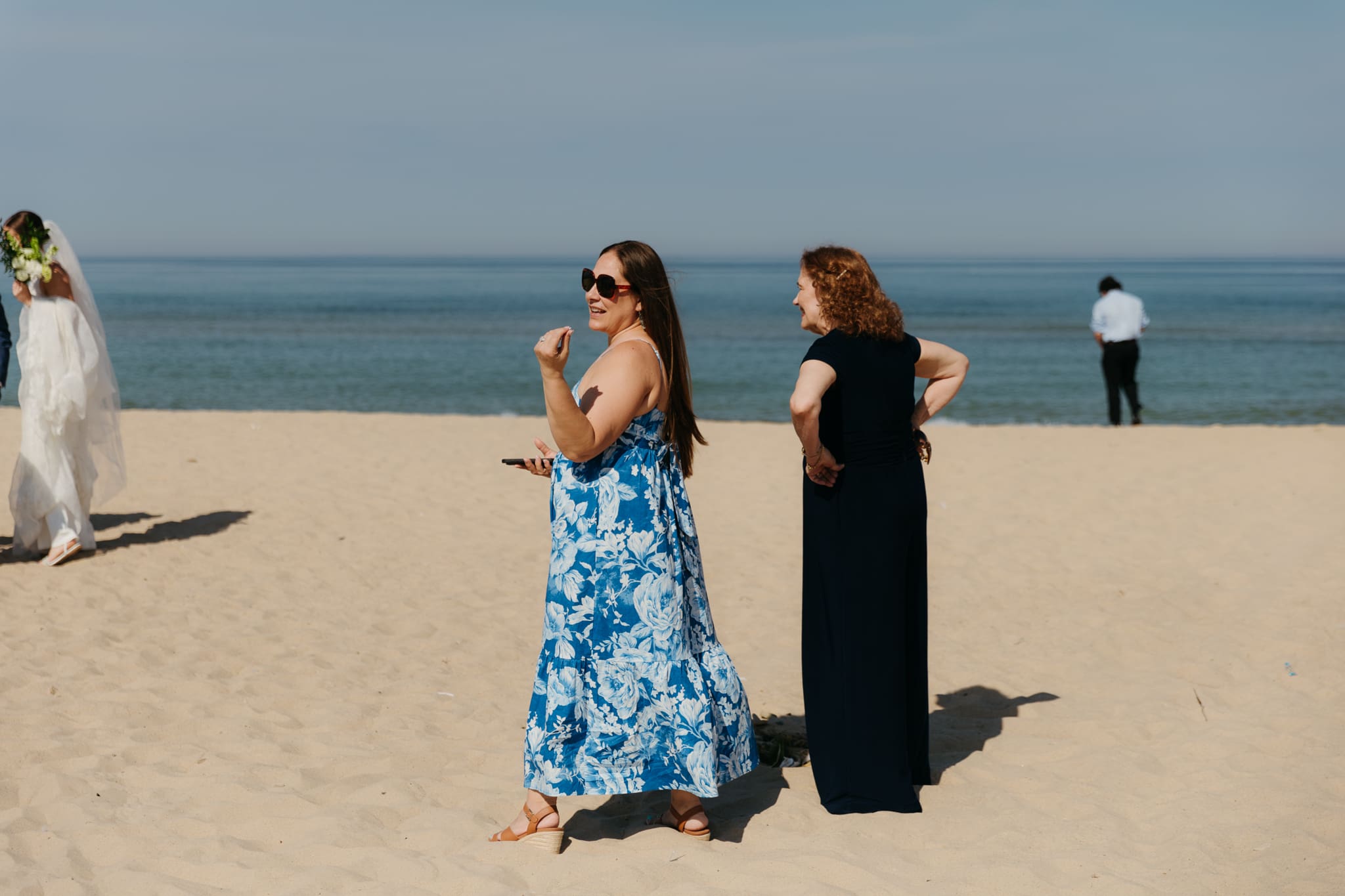 Family and friends walking along the beach towards the wedding ceremony spot at Warren Dunes State Park in Michigan