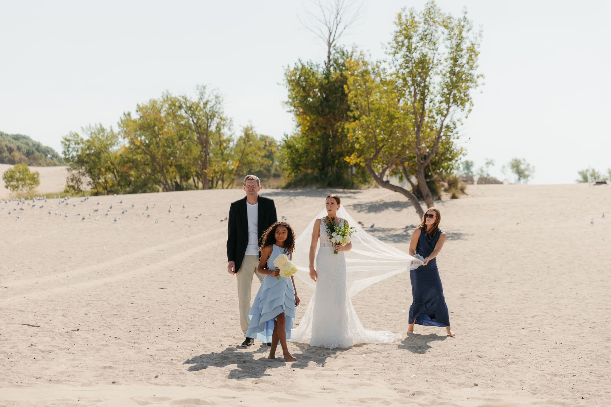 Family and friends hang out and talk on the beach at Warren Dunes State Park, while waiting for a wedding ceremony to begin