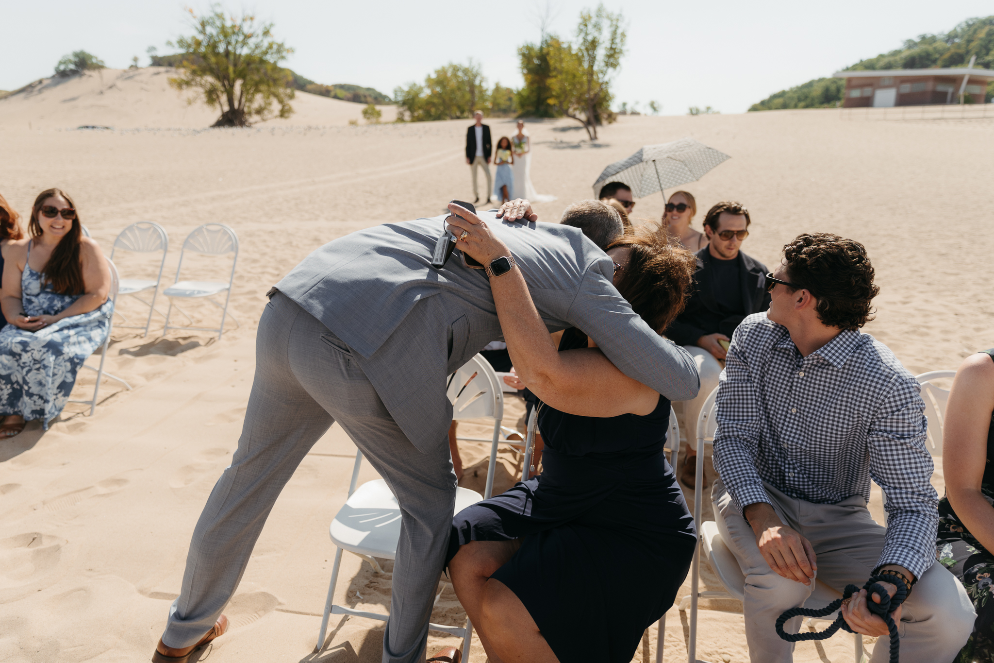 Groom walks down the aisle during a beach wedding ceremony at Warren Dunes State Park