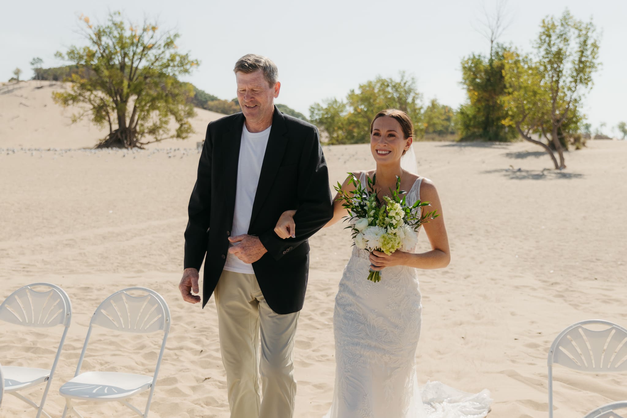 Bride walks down the aisle during a sunny beach wedding at Warren Dunes State Park on Lake Michigan