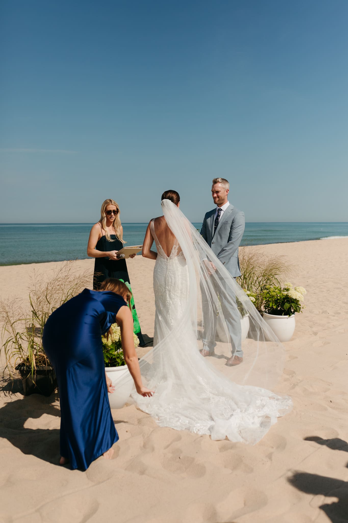Bride and groom exchange vows on the beach during their Lake Michigan wedding ceremony at Warren Dunes State Park