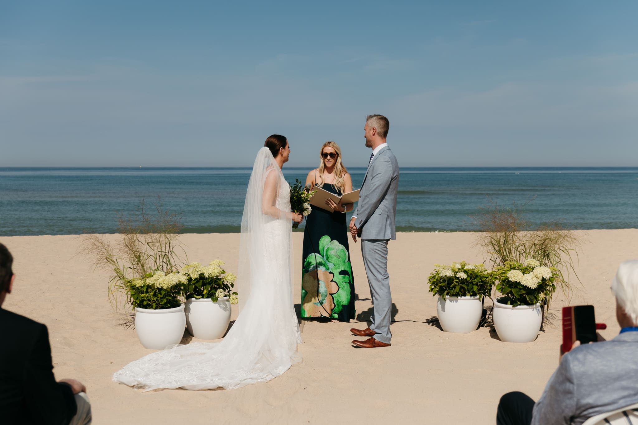 Bride and groom exchange vows on the beach during their Lake Michigan wedding ceremony at Warren Dunes State Park