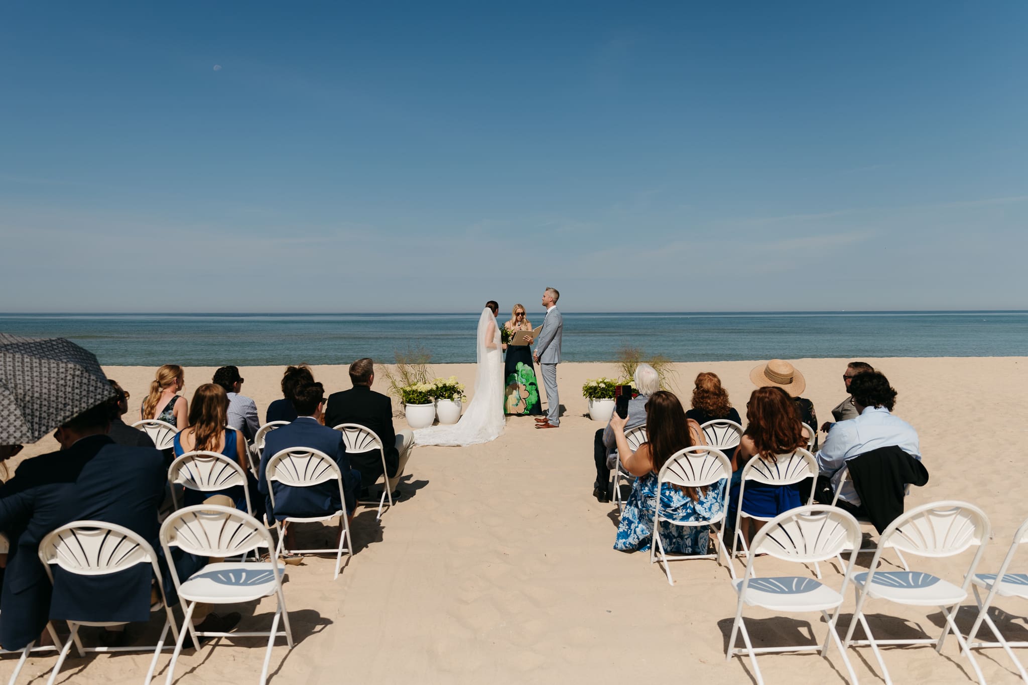 Bride and groom exchange vows on the beach during their Lake Michigan wedding ceremony at Warren Dunes State Park