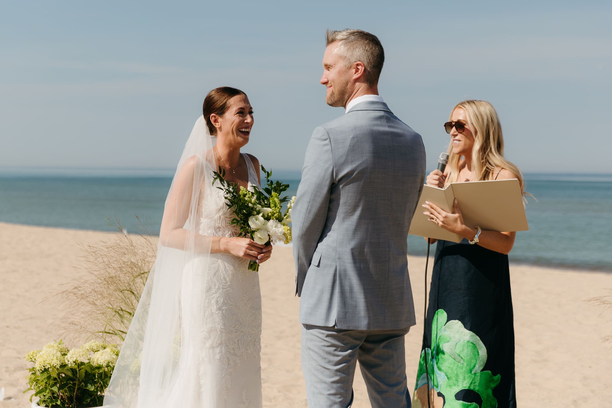 Bride and groom exchange vows on the beach during their Lake Michigan wedding ceremony at Warren Dunes State Park