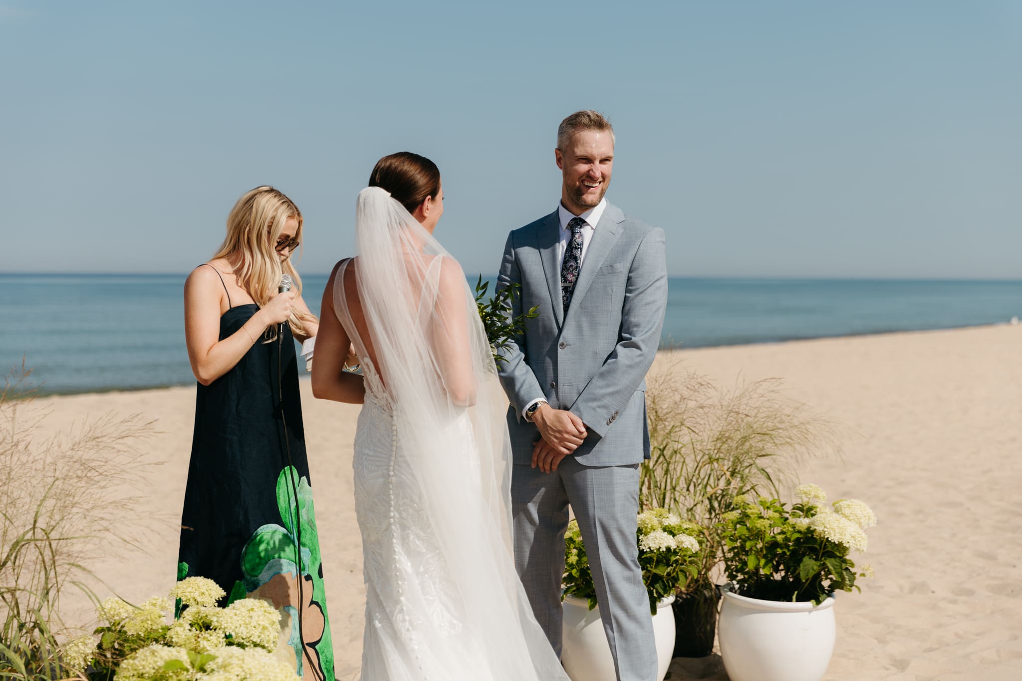 Bride and groom exchange vows on the beach during their Lake Michigan wedding ceremony at Warren Dunes State Park