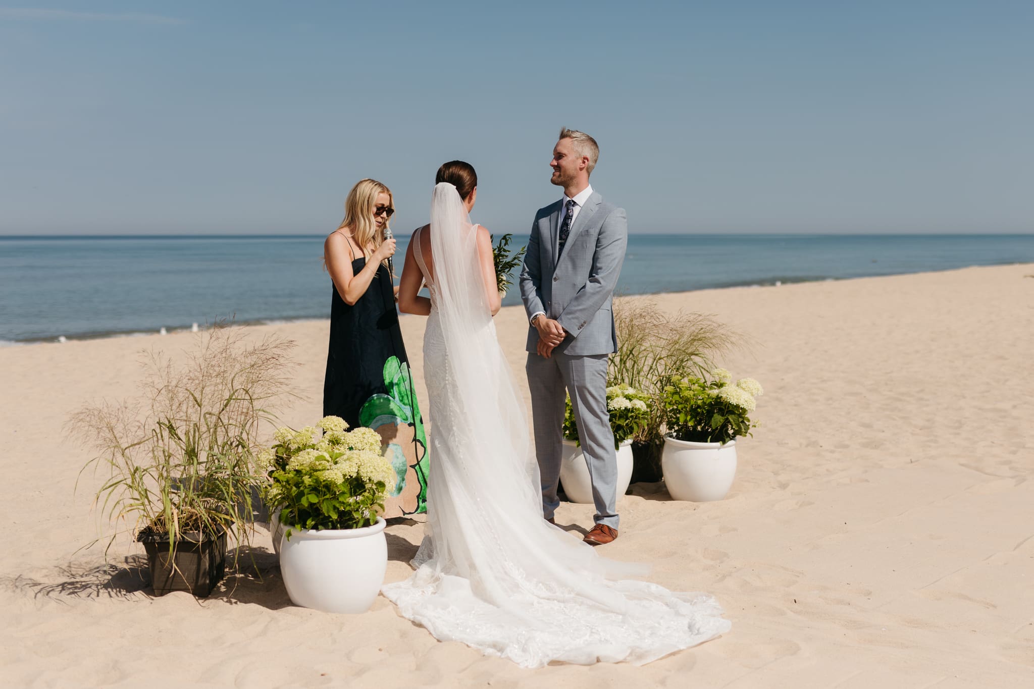 Bride and groom exchange vows on the beach during their Lake Michigan wedding ceremony at Warren Dunes State Park