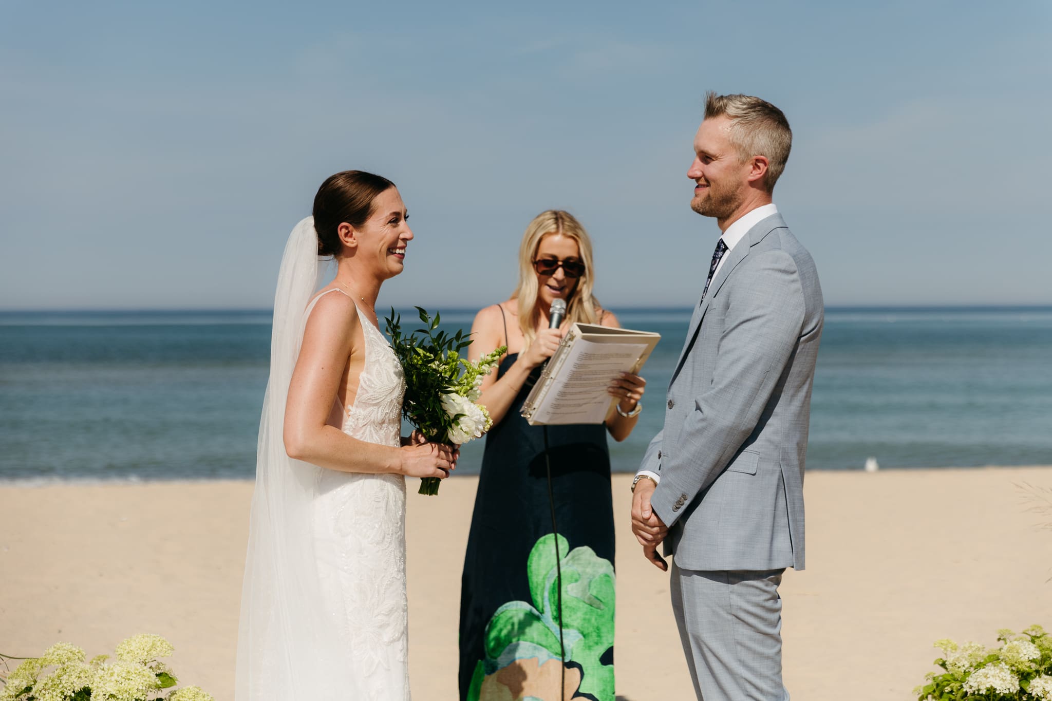 Bride and groom exchange vows on the beach during their Lake Michigan wedding ceremony at Warren Dunes State Park