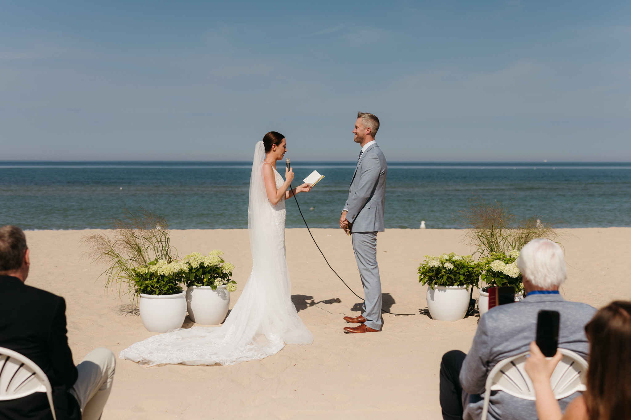 Bride and groom exchange vows on the beach during their Lake Michigan wedding ceremony at Warren Dunes State Park