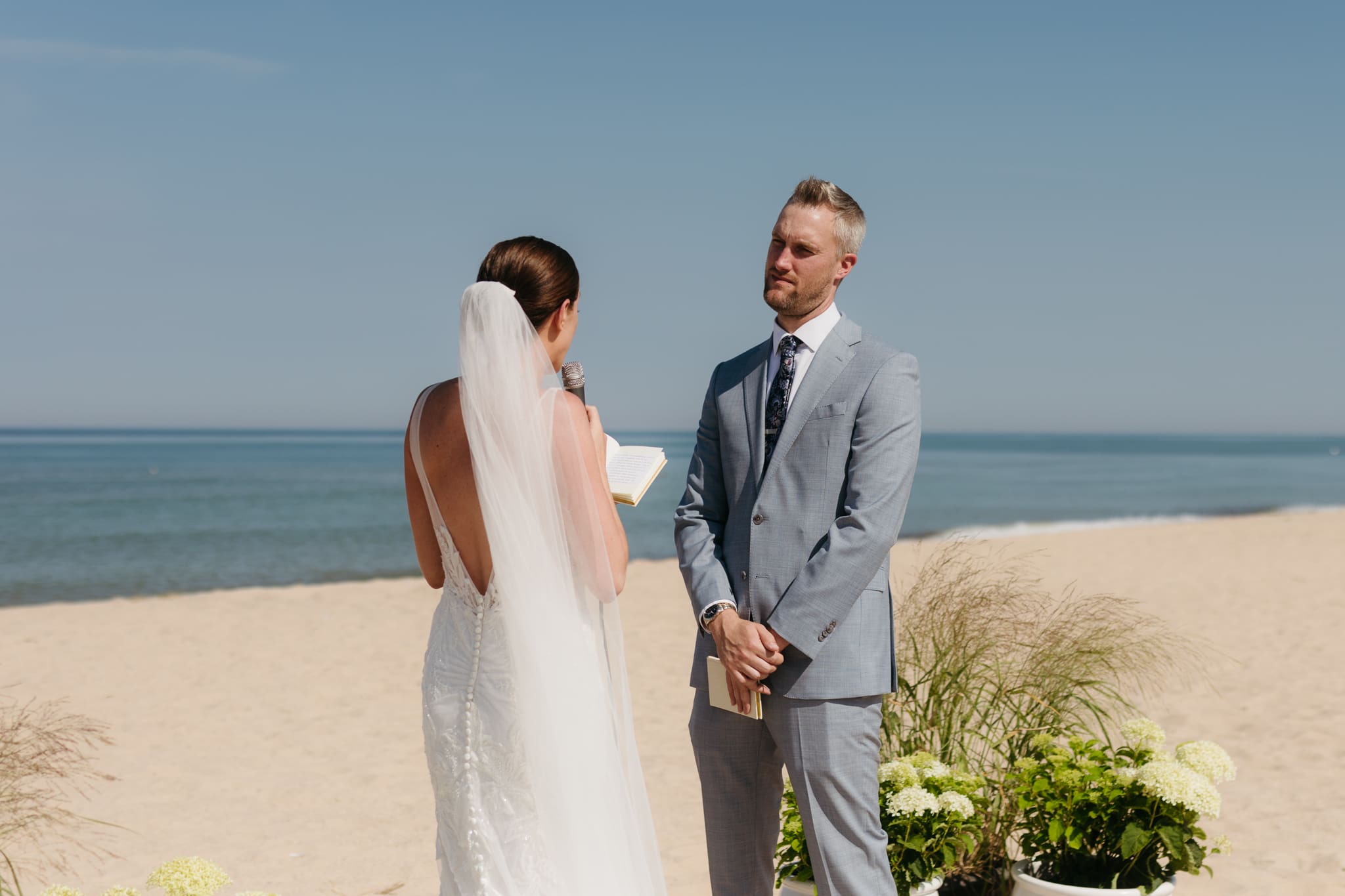 Bride and groom exchange vows on the beach during their Lake Michigan wedding ceremony at Warren Dunes State Park